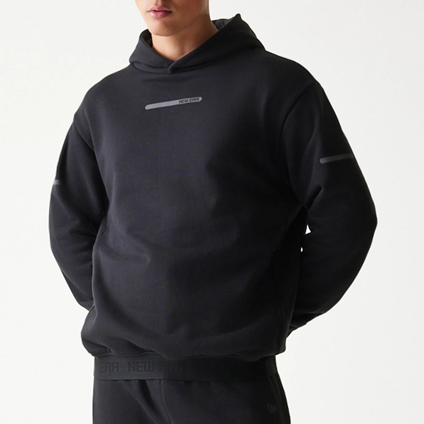The model is wearing this New Era Tech Oversized Pullover Hoodie in black. 7