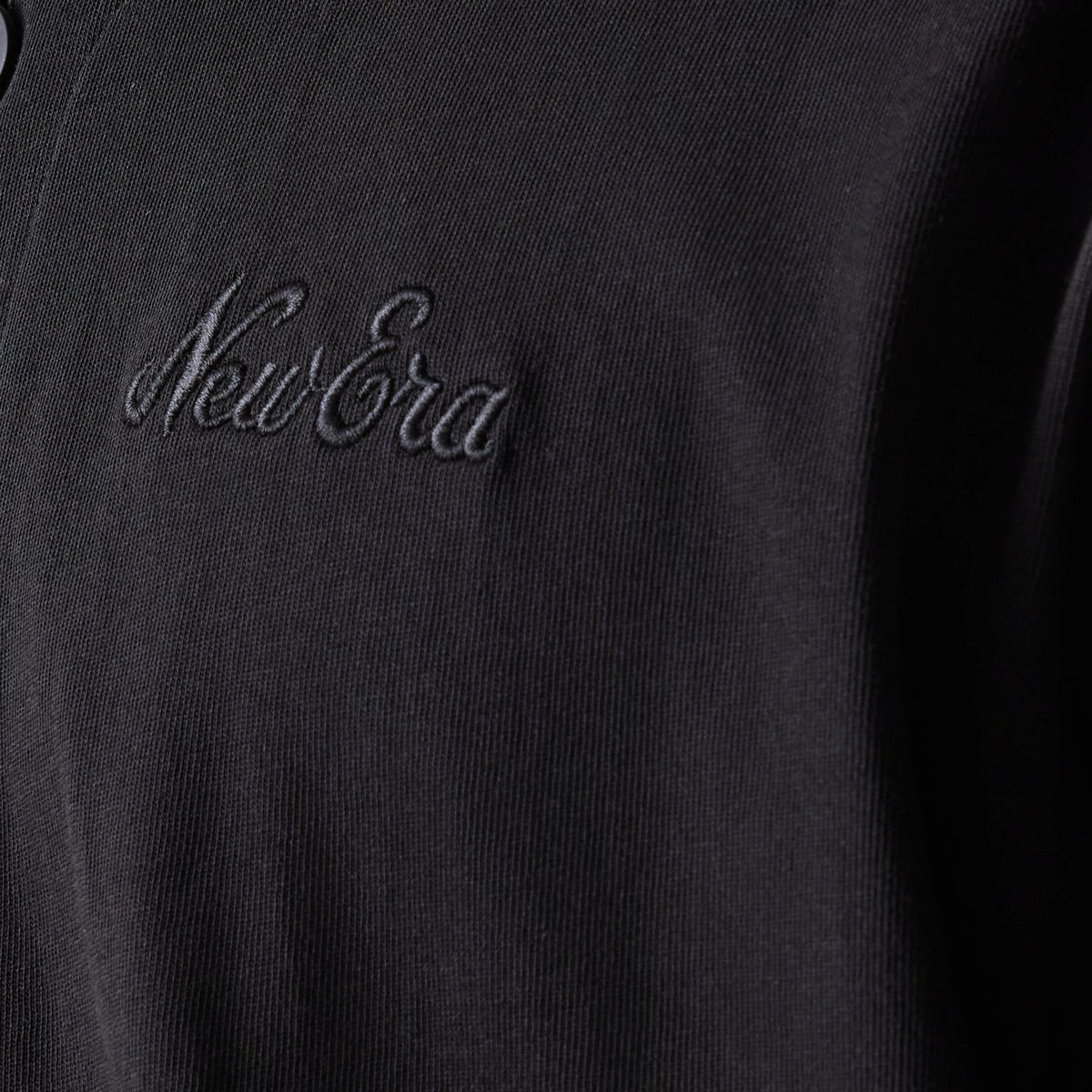 The model is wearing this New Era Open Heritage Script T-Shirt in black. 5