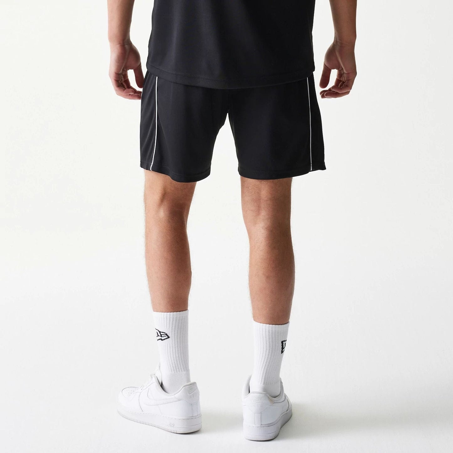 The model is wearing this New Era Football Shorts in black. 2