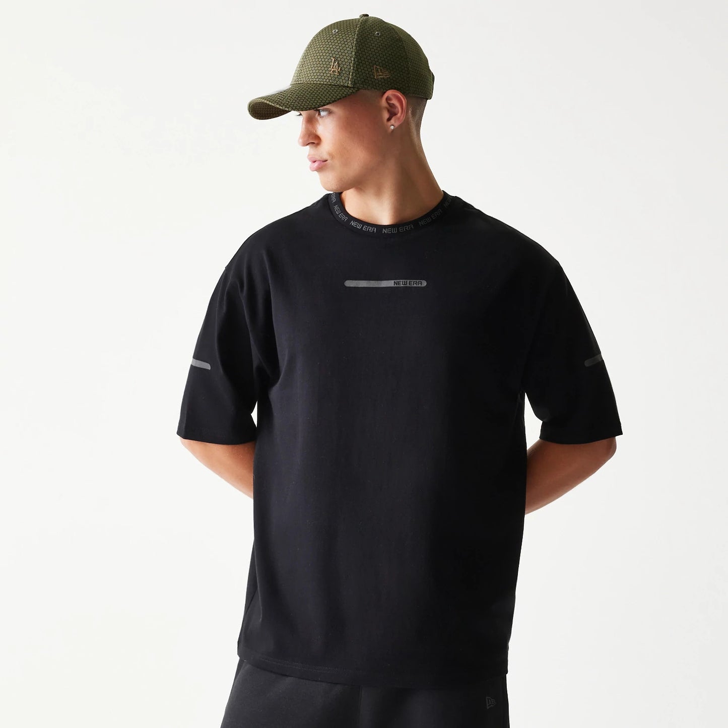 The model is wearing this New Era Tech Oversized T-Shirt in black. 1