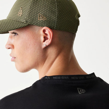 The model is wearing this New Era Tech Oversized T-Shirt in black. 5