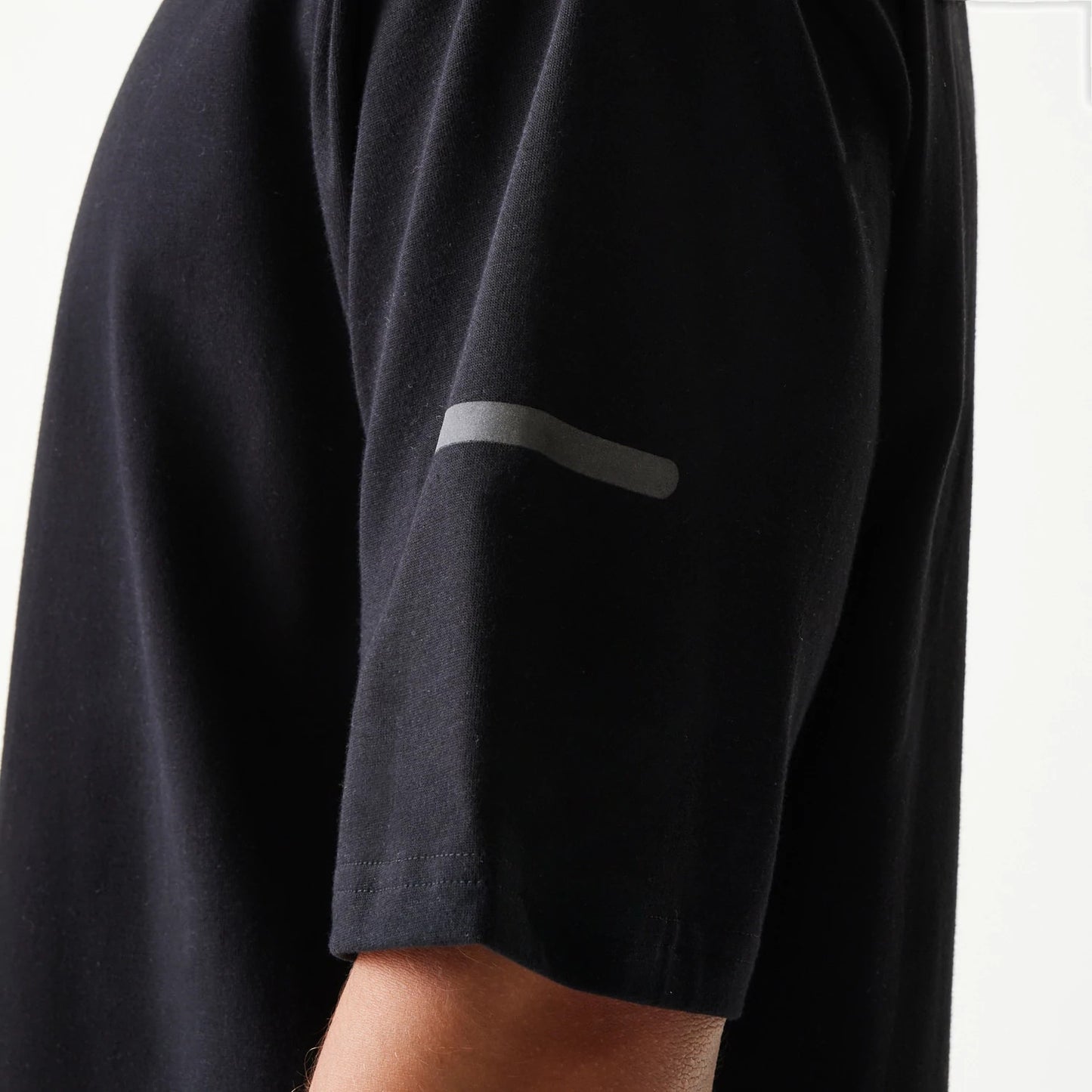 The model is wearing this New Era Tech Oversized T-Shirt in black. 6