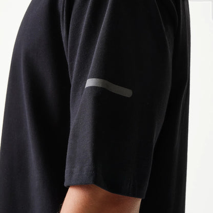 The model is wearing this New Era Tech Oversized T-Shirt in black. 6