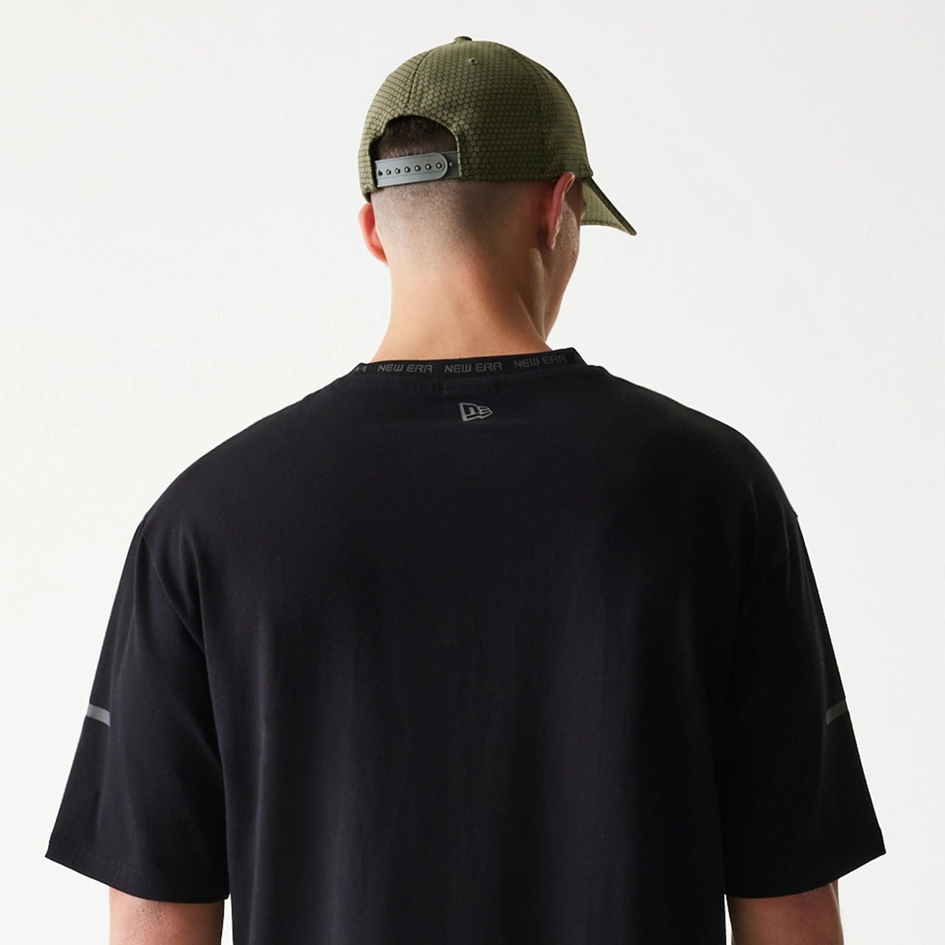 The model is wearing this New Era Tech Oversized T-Shirt in black. 7