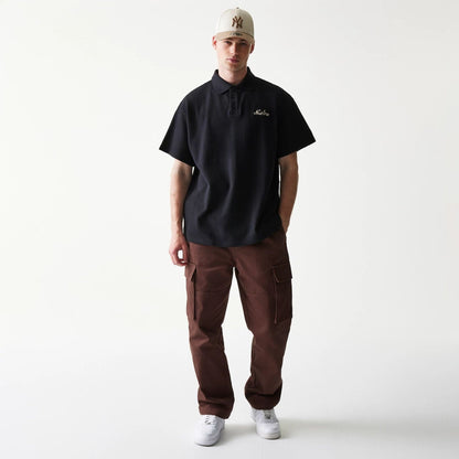 The model is wearing this New Era Graphic Polo T-Shirt in black. 8