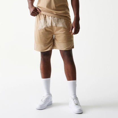 The model is wearing this New Era Mesh Graphic Oversized Shorts in light beige. 3