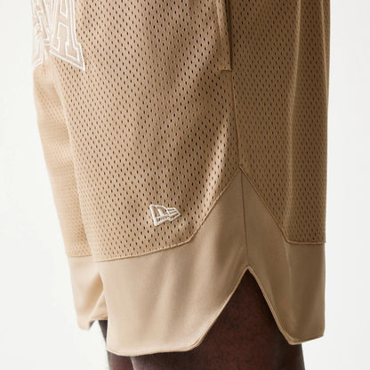 The model is wearing this New Era Mesh Graphic Oversized Shorts in light beige. 5