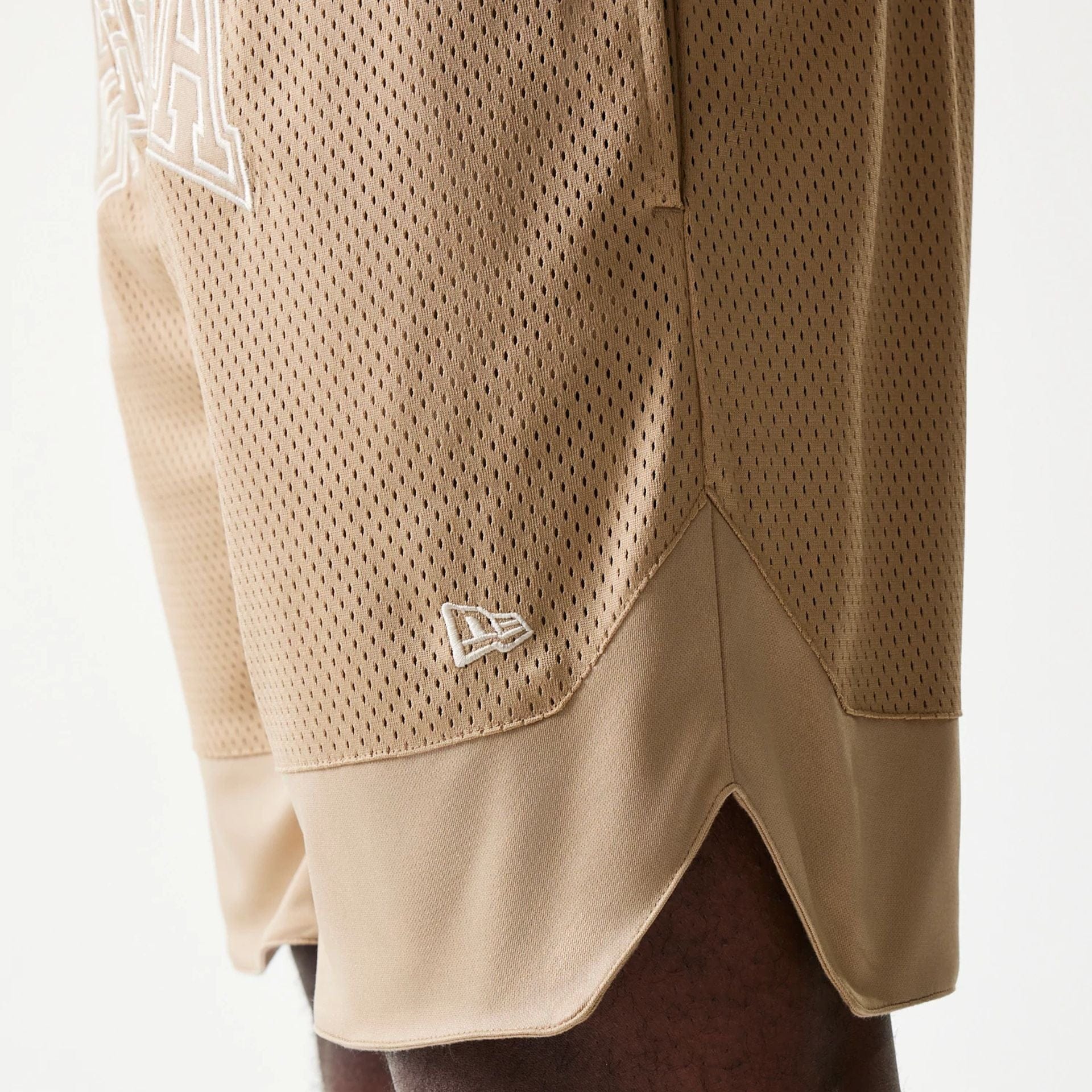 The model is wearing this New Era Mesh Graphic Oversized Shorts in light beige. 5