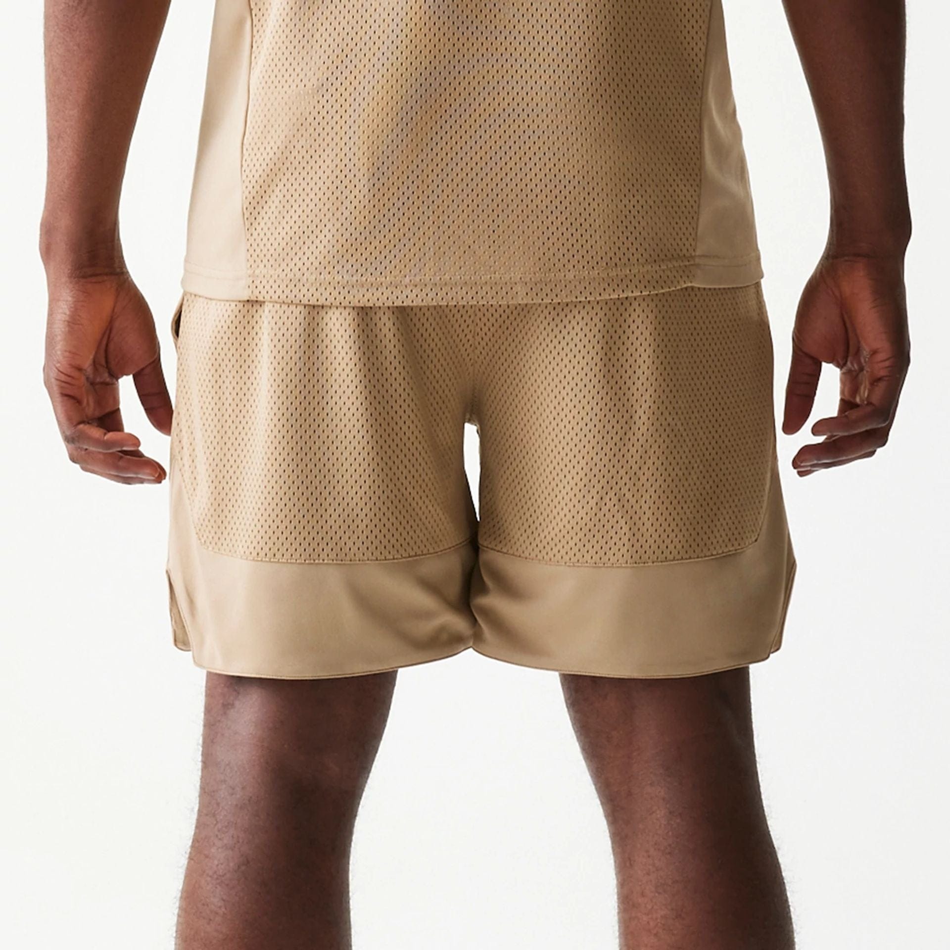 The model is wearing this New Era Mesh Graphic Oversized Shorts in light beige. 7
