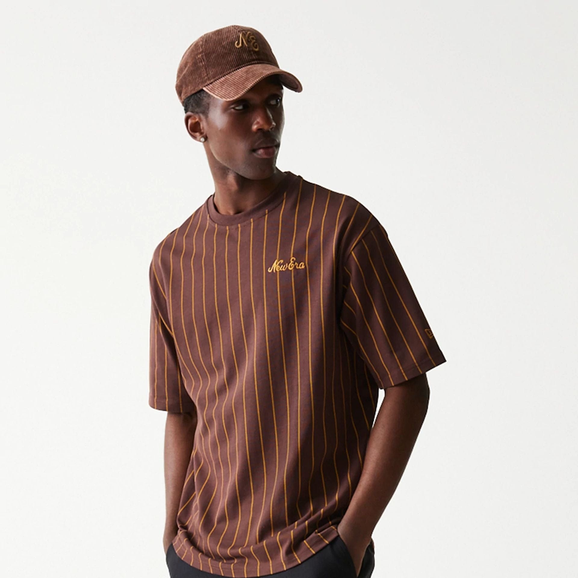 The model is wearing this New Era Pinstripe Oversized T-Shirt in brown. 3