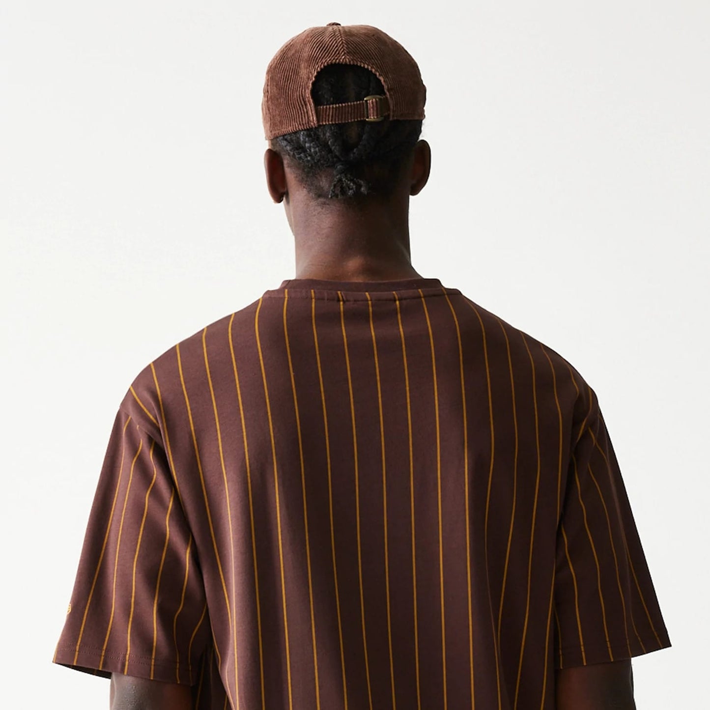 The model is wearing this New Era Pinstripe Oversized T-Shirt in brown. 7