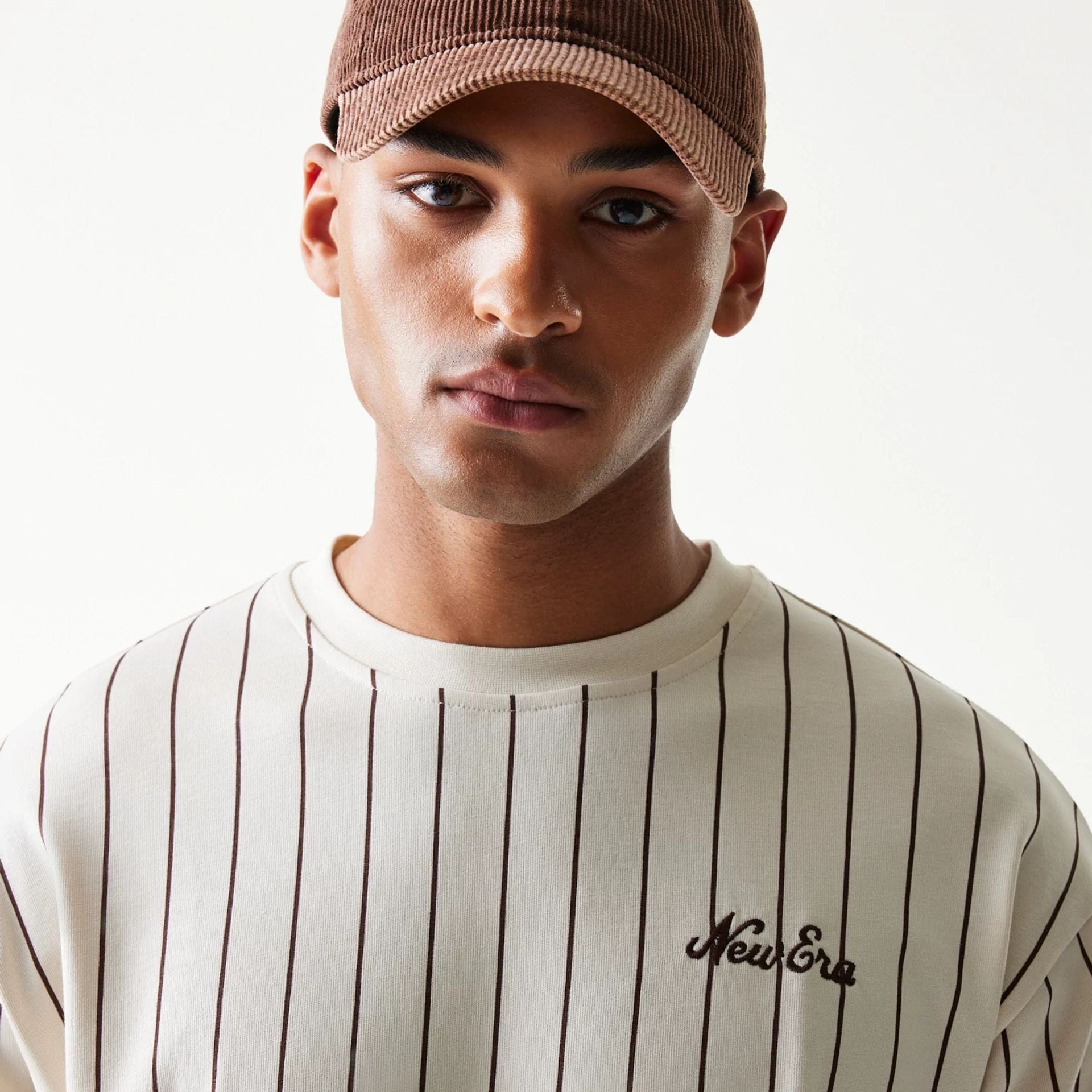 The model is wearing this New Era Pinstripe Oversized T-Shirt in light beige. 6