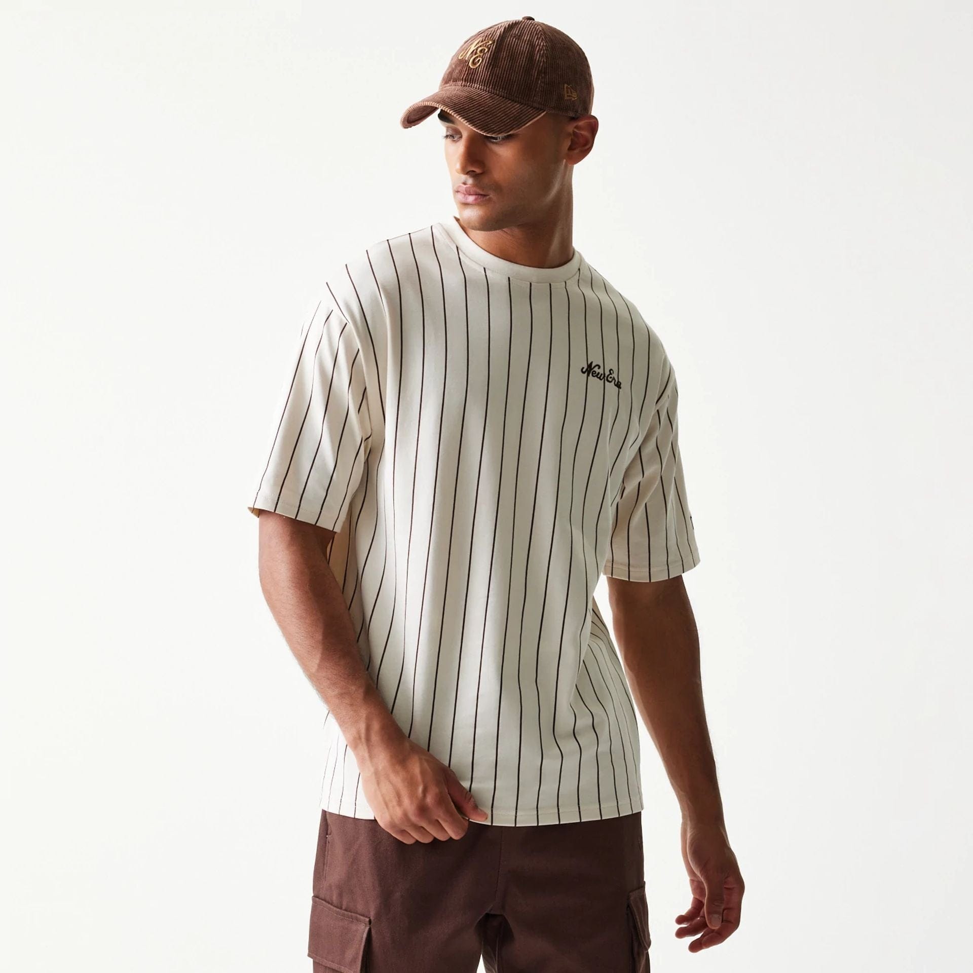 The model is wearing this New Era Pinstripe Oversized T-Shirt in light beige. 1