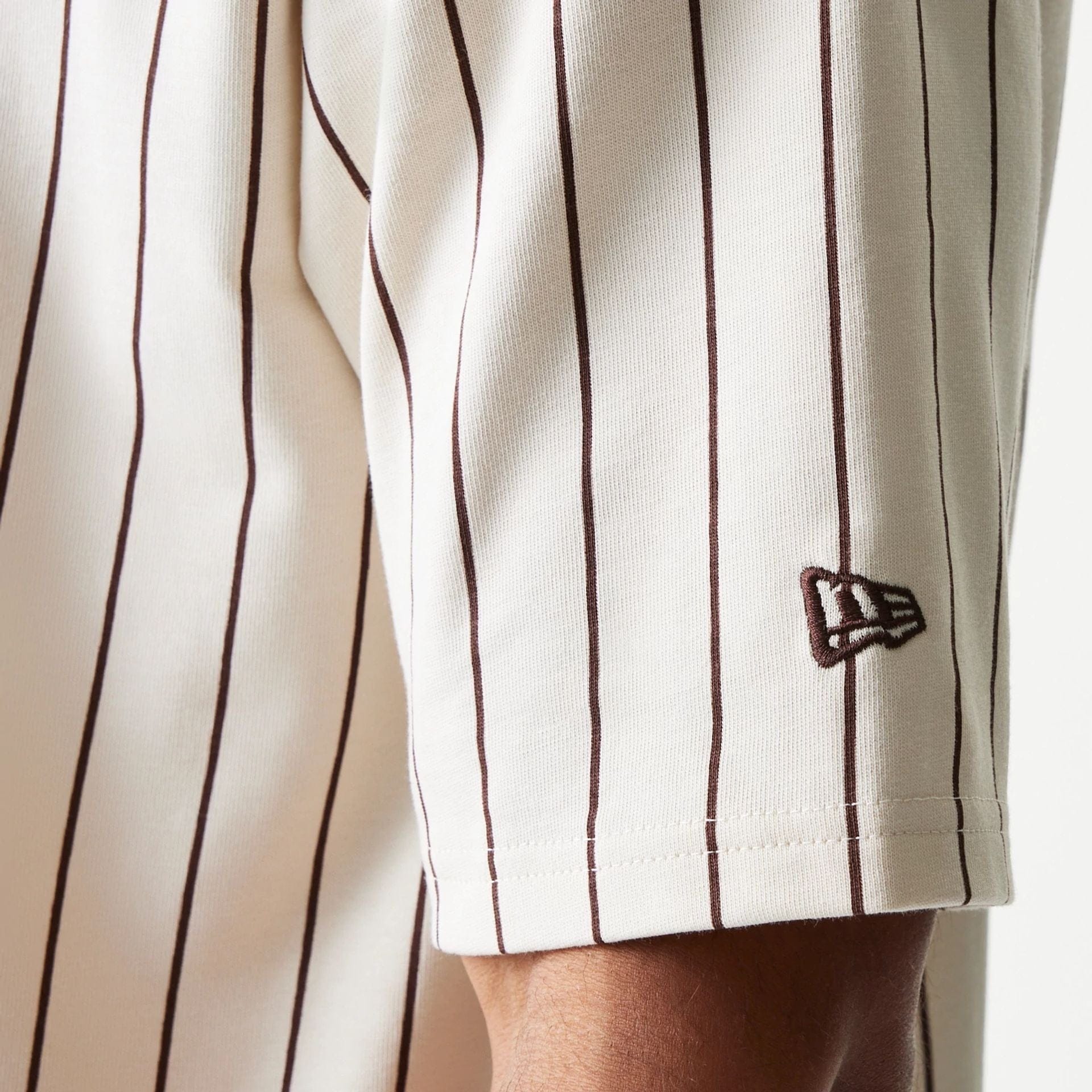 The model is wearing this New Era Pinstripe Oversized T-Shirt in light beige. 5
