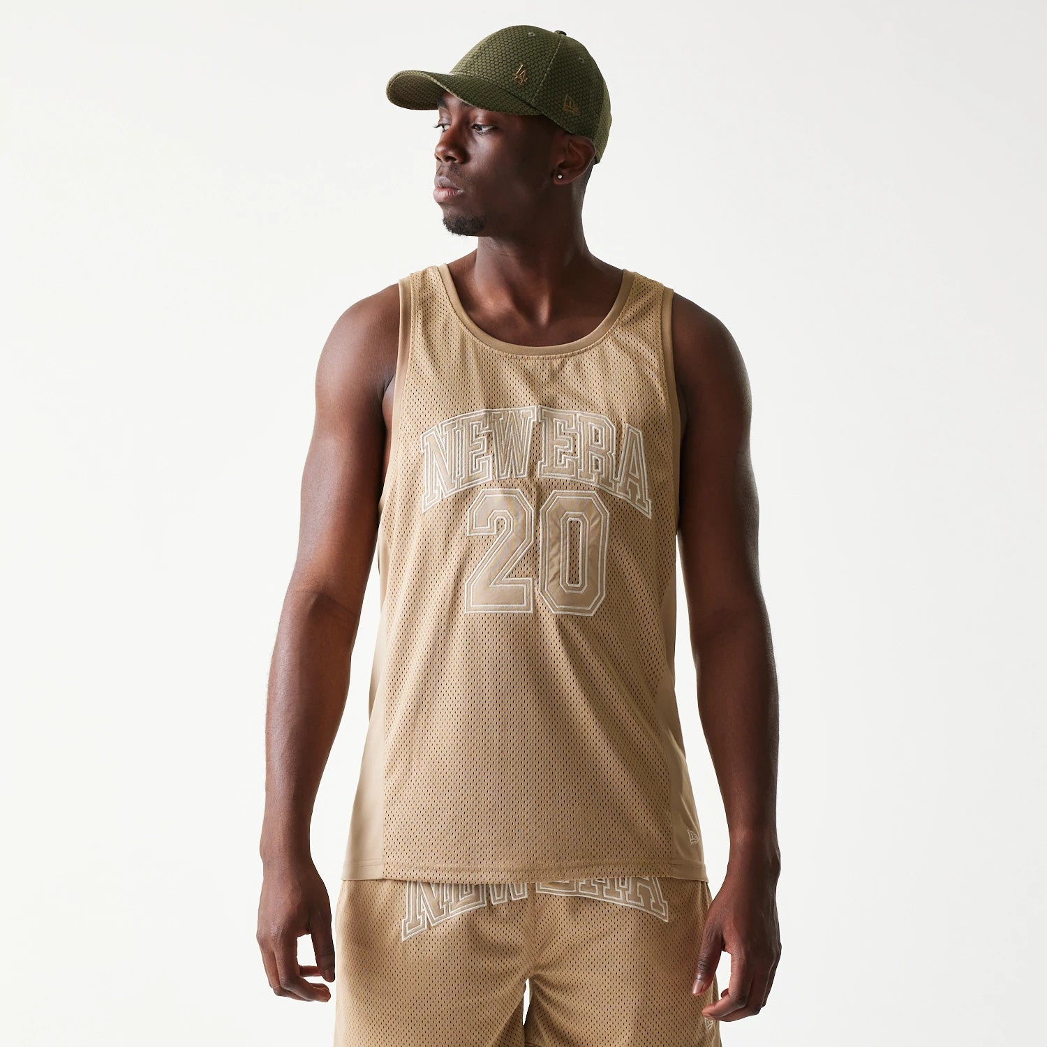 The model is wearing this New Era Mesh Tank Top in light beige. 3