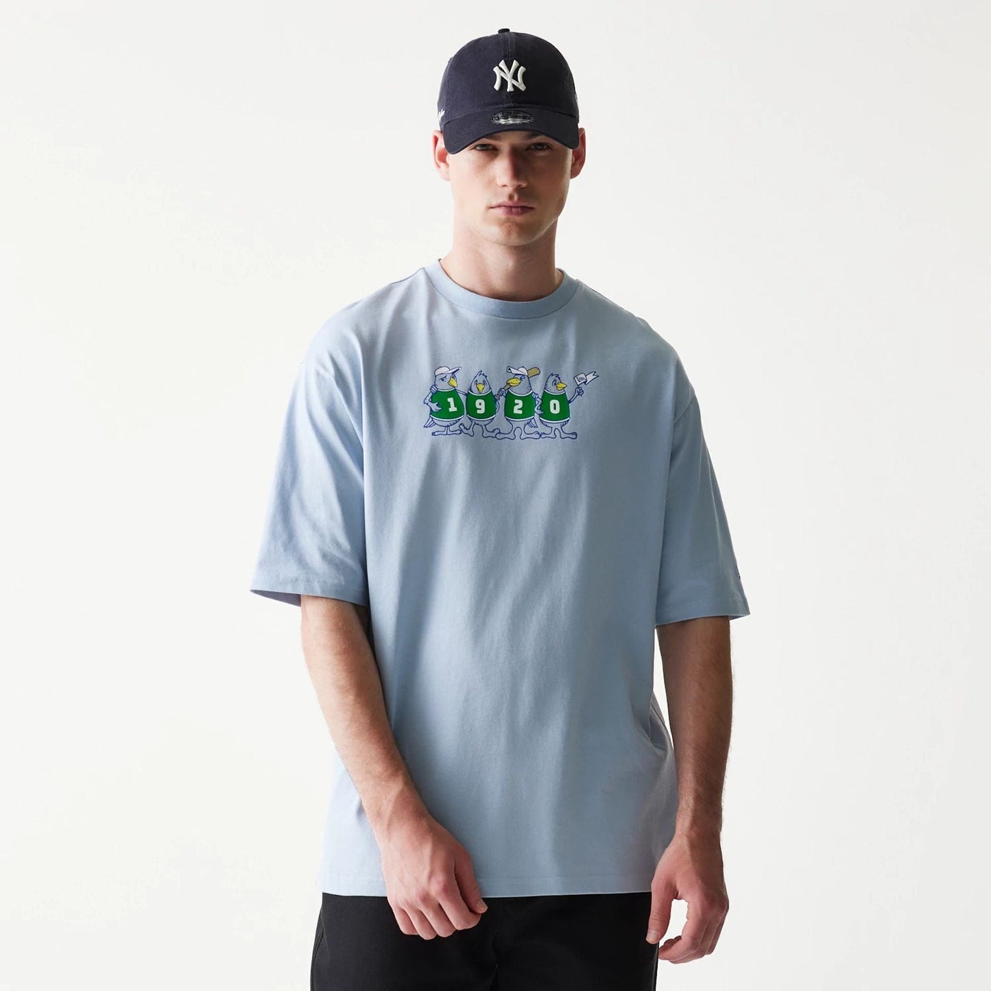 The model is wearing this New Era Baseball Birds Character Graphic Oversized T-Shirt in pastel blue. 3