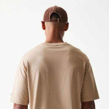 The model is wearing this New Era Orange Fruit Graphic Oversized T-Shirt in light beige. 7