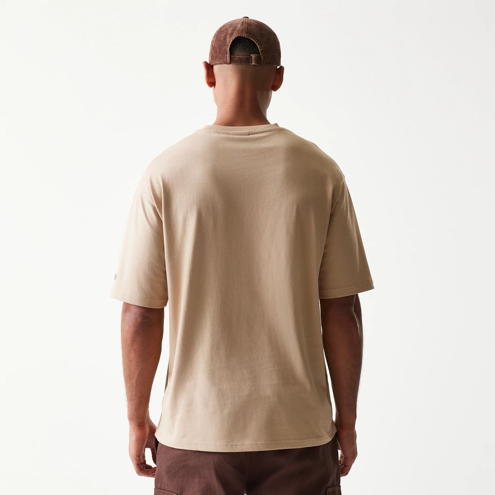The model is wearing this New Era Orange Fruit Graphic Oversized T-Shirt in light beige. 2