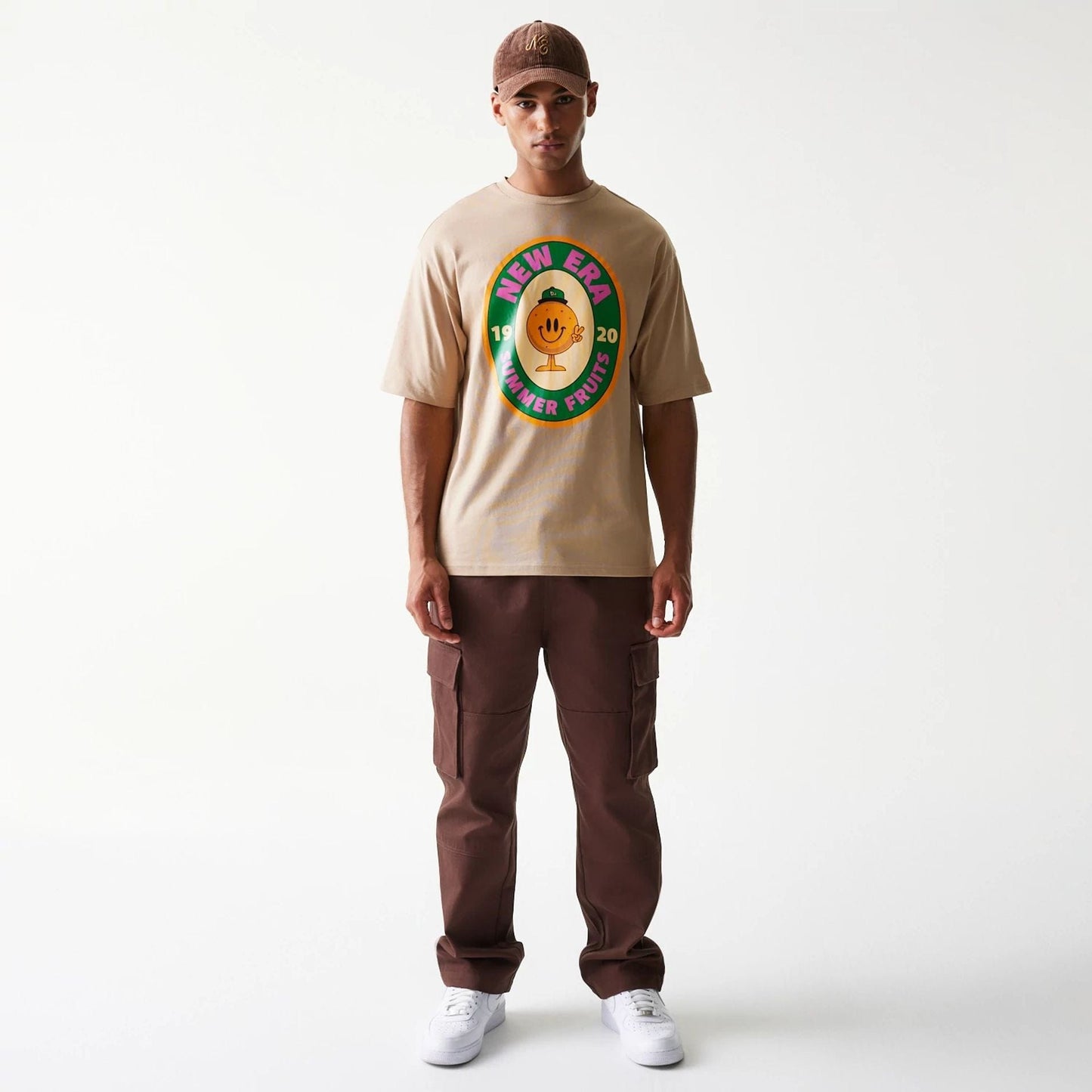 The model is wearing this New Era Orange Fruit Graphic Oversized T-Shirt in light beige. 8