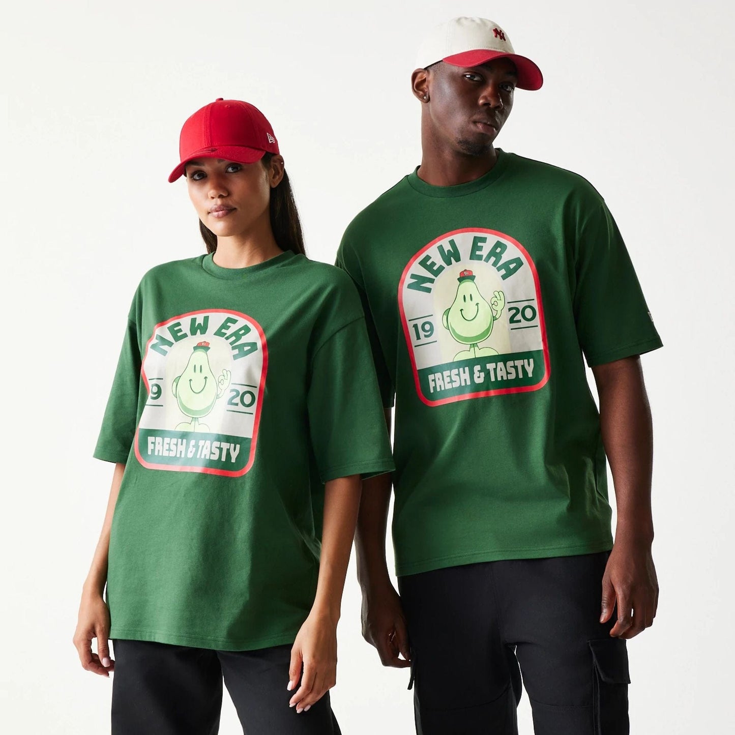 The model is wearing this New Era Pear Fruit Graphic Oversized T-Shirt in dark green. 1