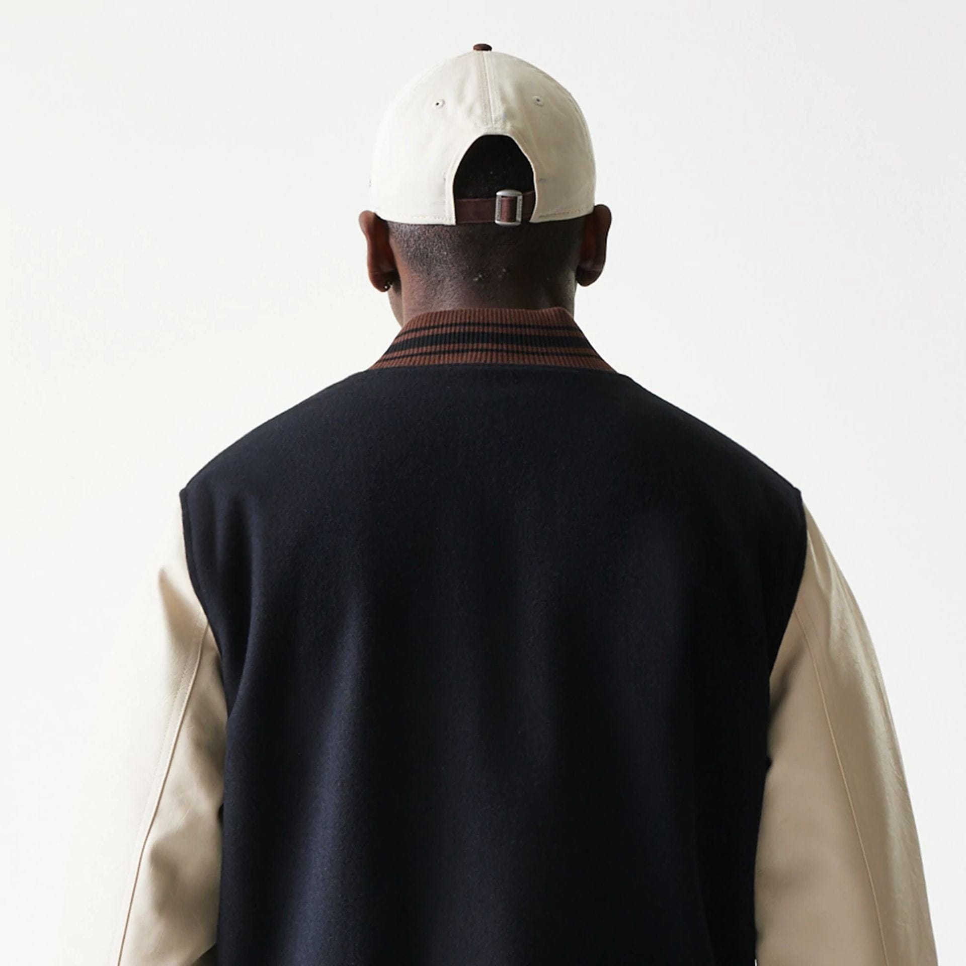 The model is wearing this New Era Varsity Jacket in black. 8