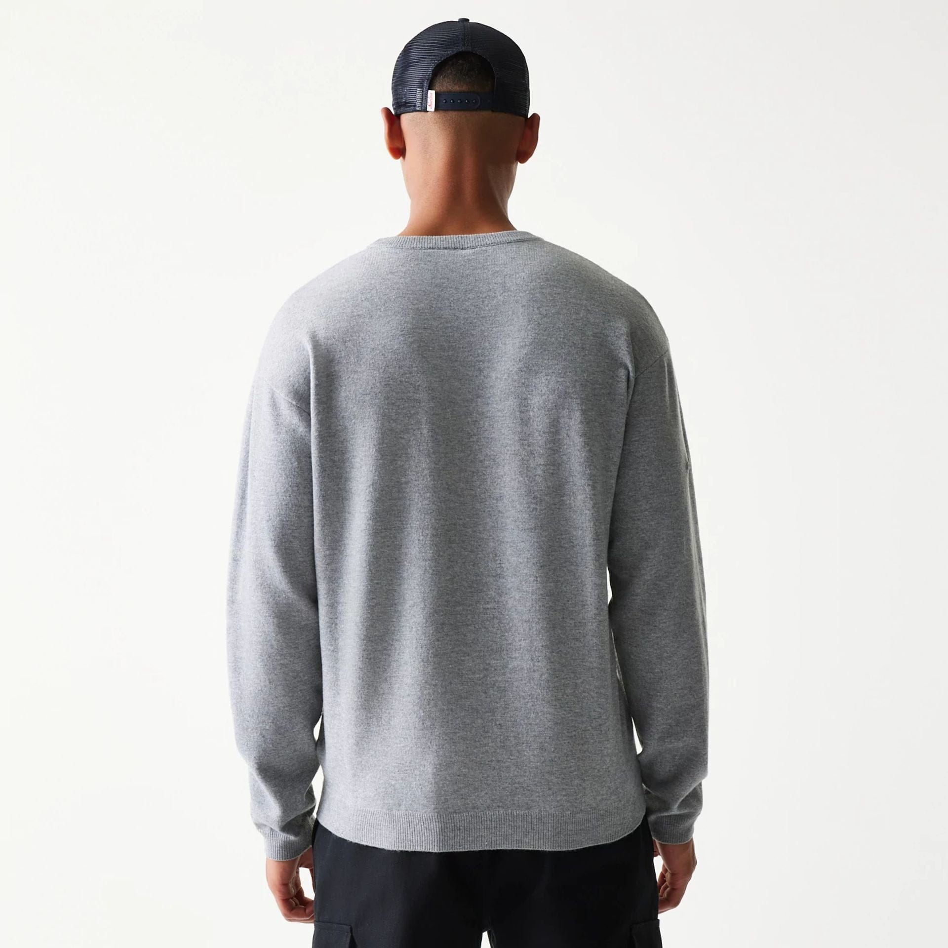 The model is wearing this New Era Essential Flag Knitted Sweater in grey. 2