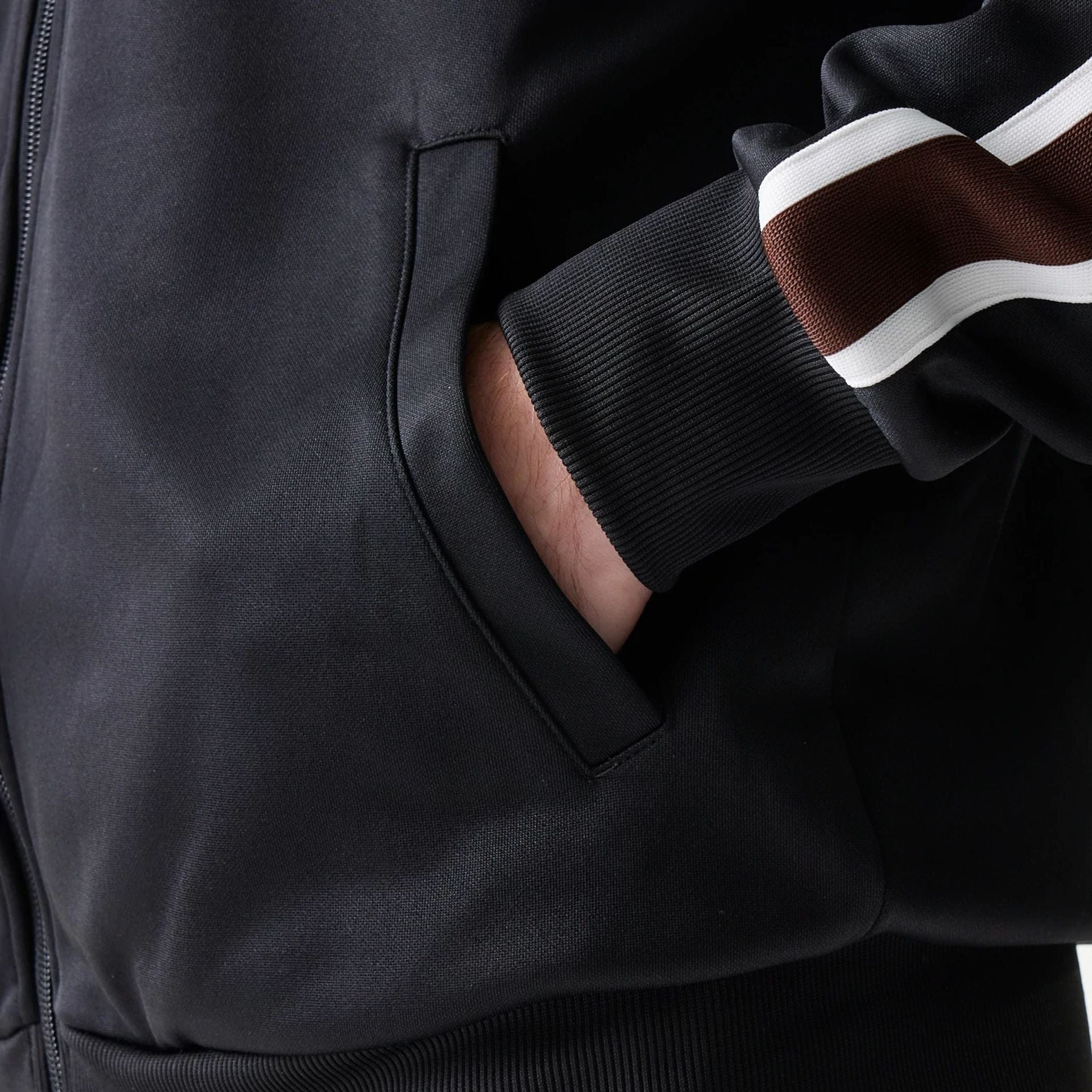 The model is wearing this New Era Script Track Jacket in black. 6