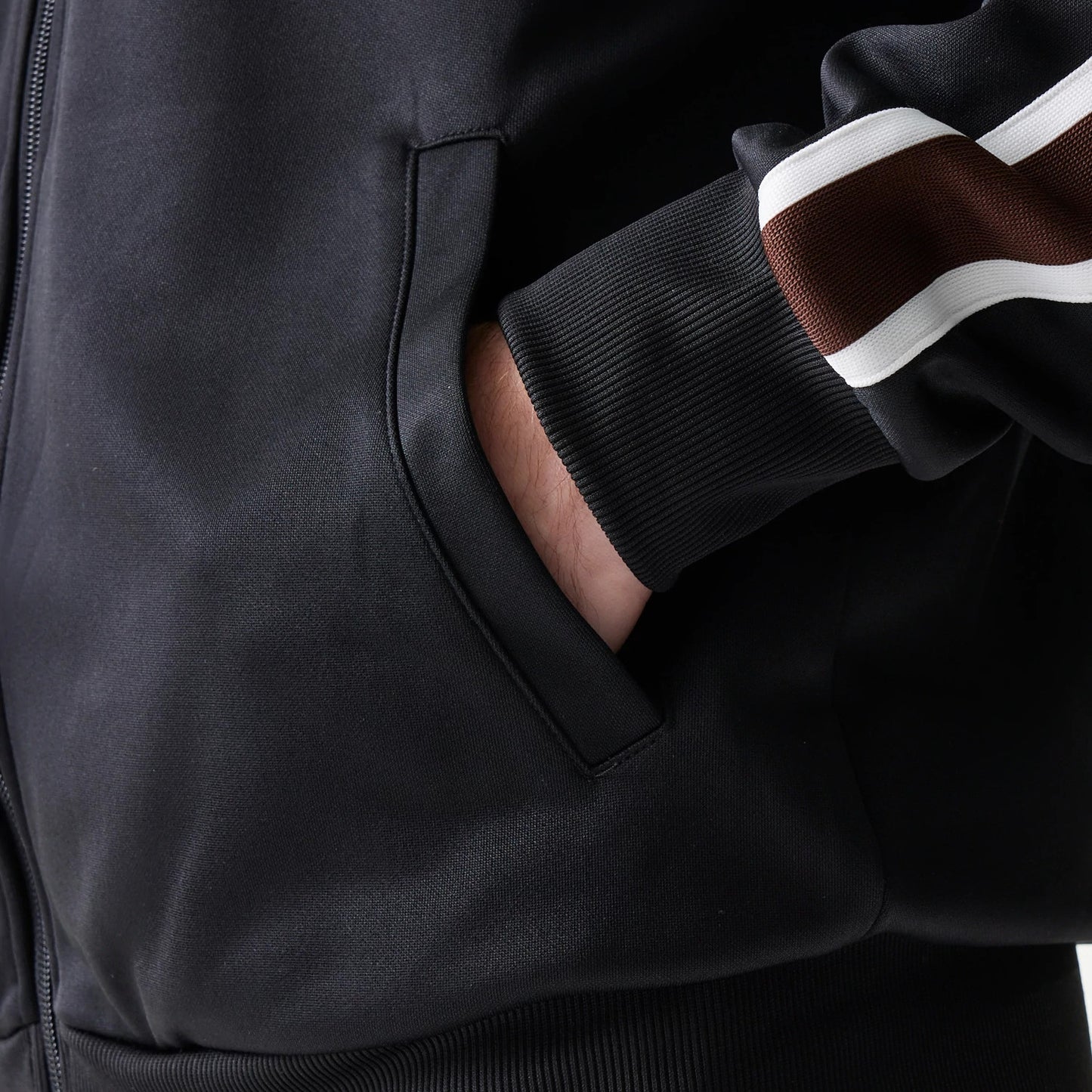 The model is wearing this New Era Script Track Jacket in black. 6