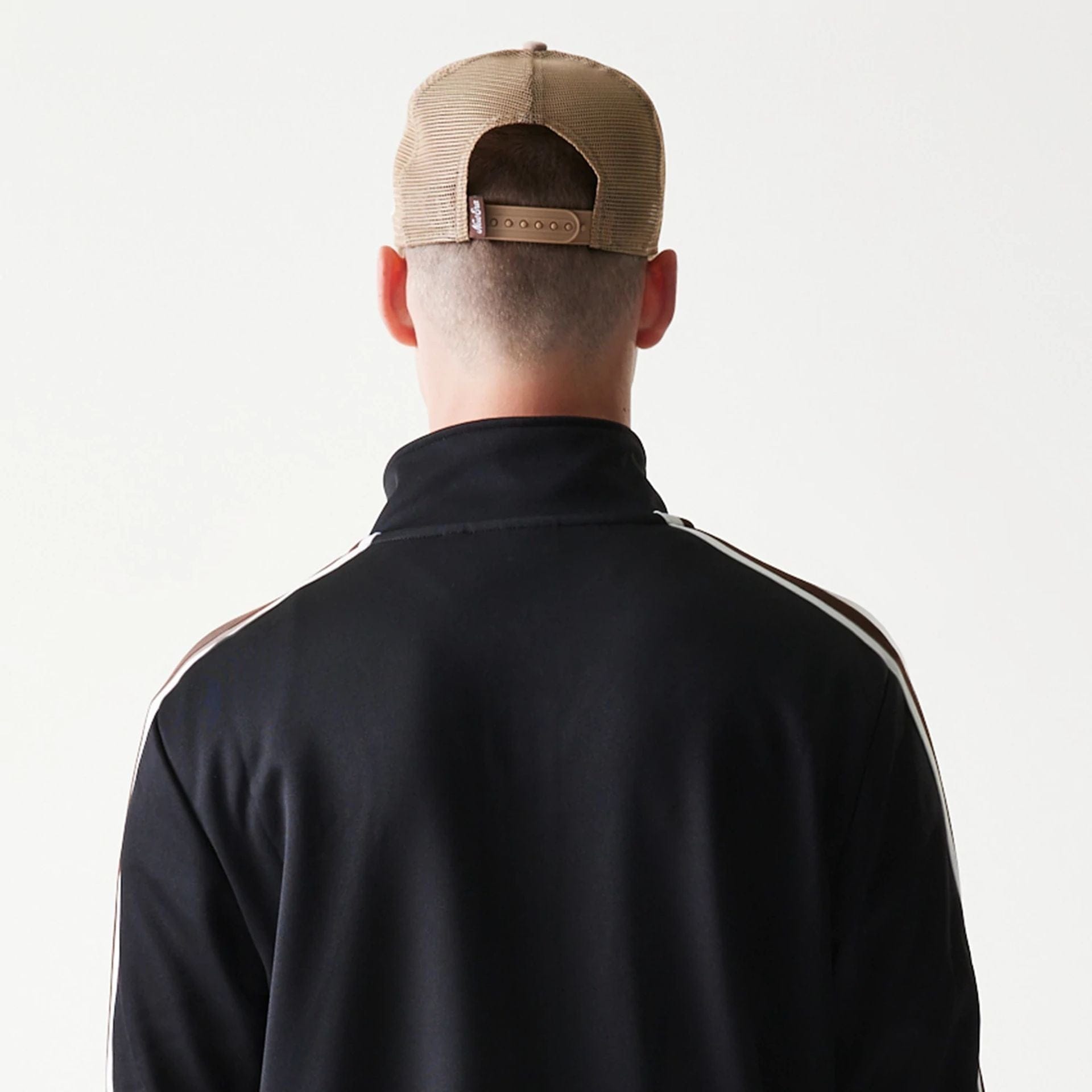 The model is wearing this New Era Script Track Jacket in black. 7