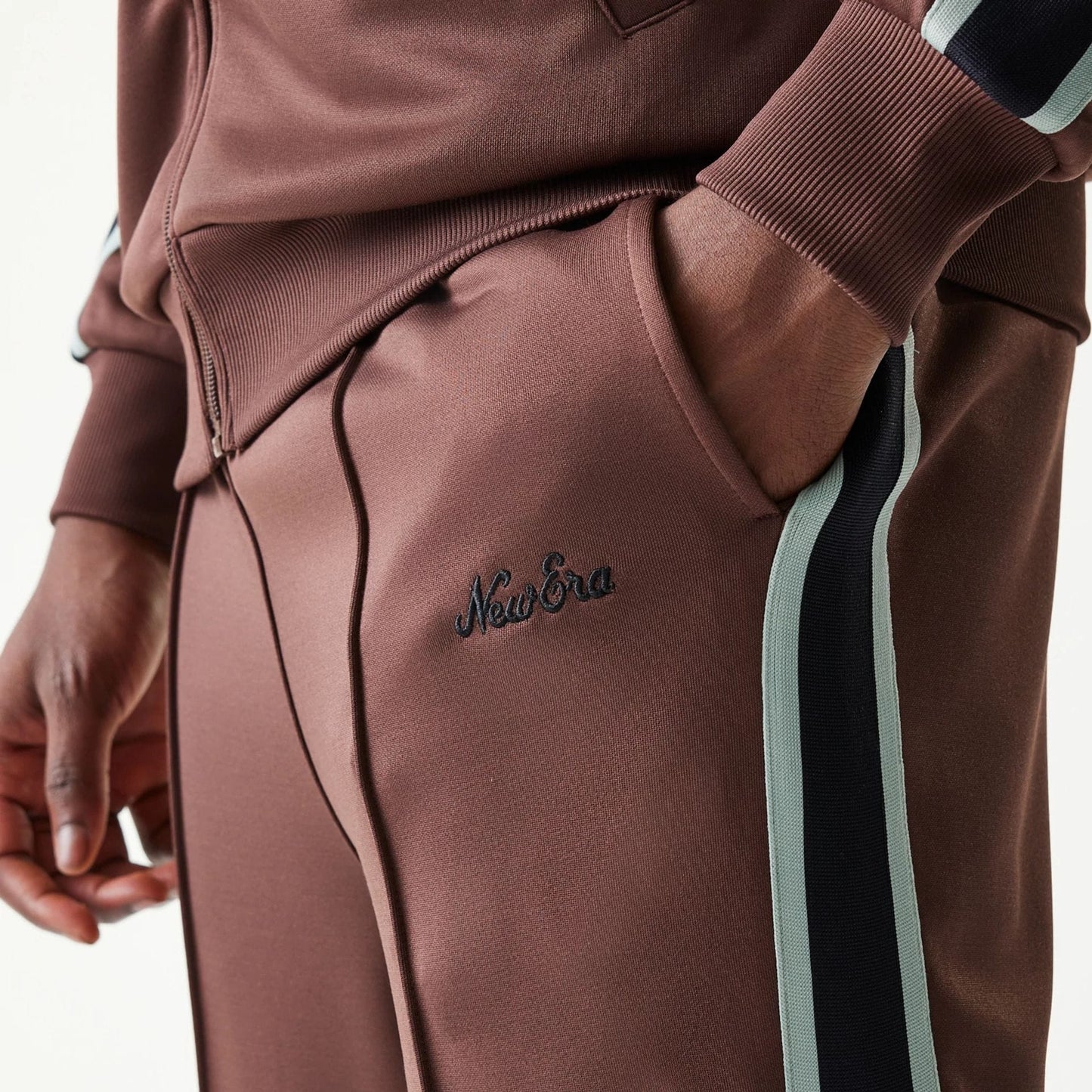 The model is wearing this New Era Script Straight Leg Joggers in brown. 4