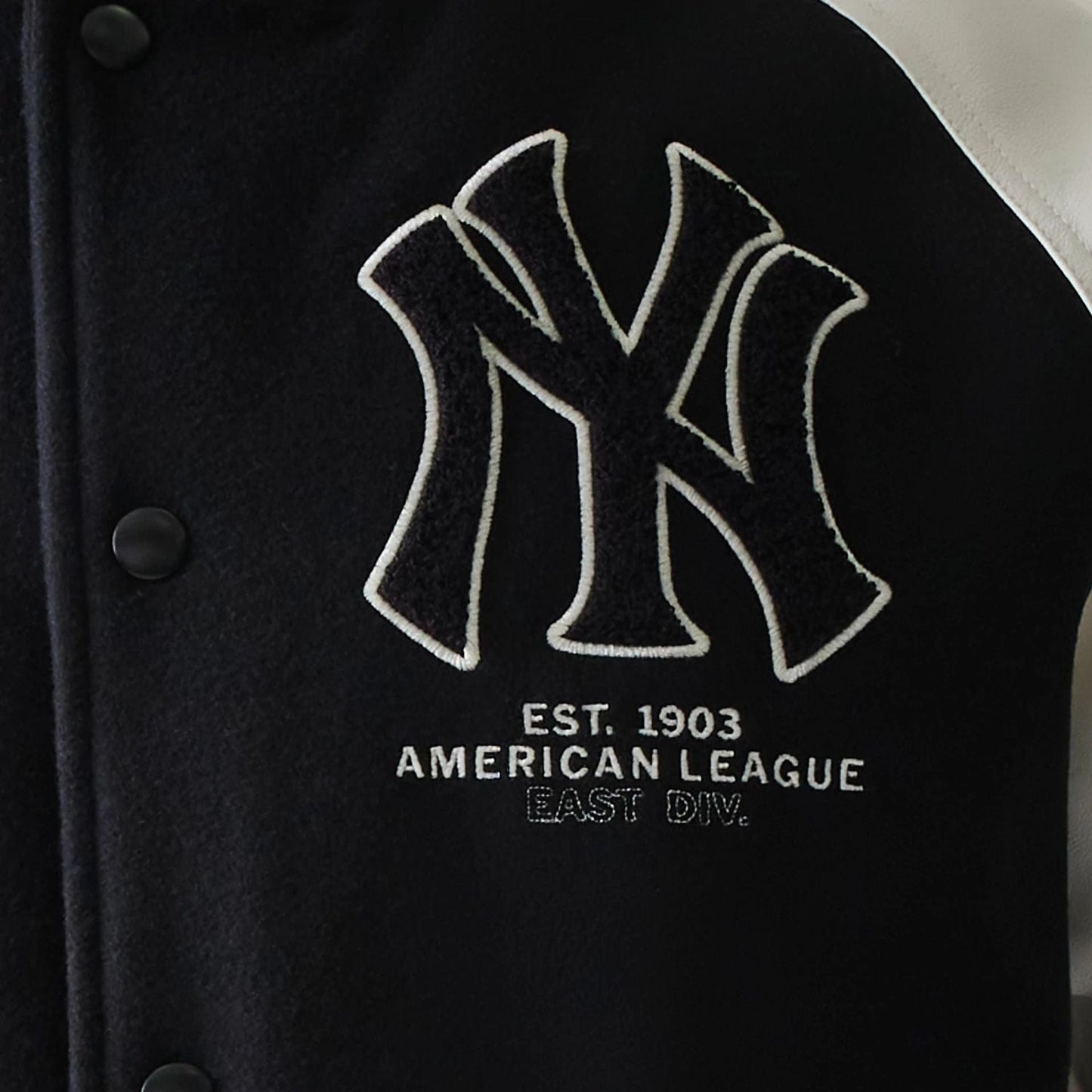 The model is wearing this MLB New York Yankees Varsity Jacket in black. 6
