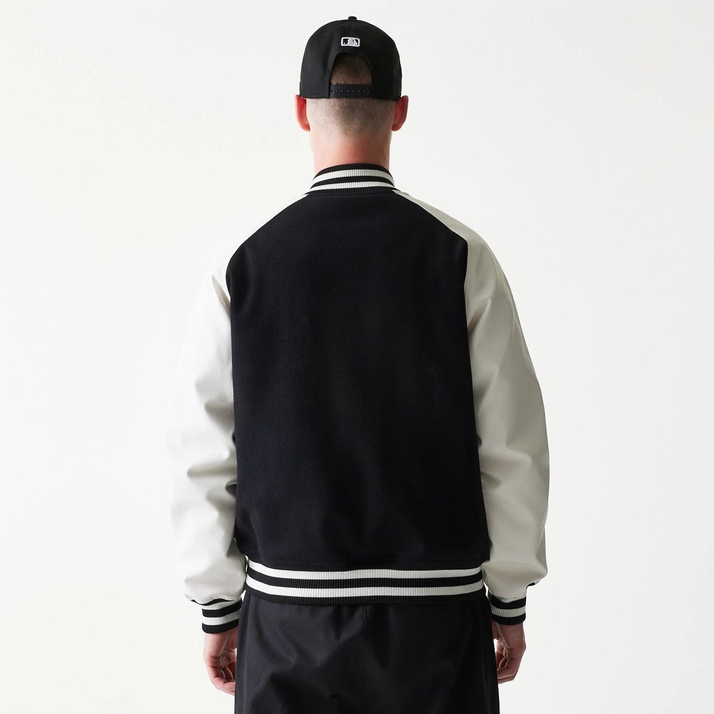 The model is wearing this MLB New York Yankees Varsity Jacket in black. 2