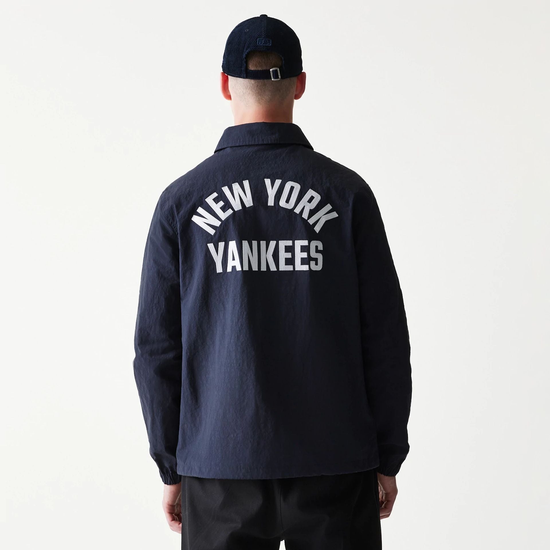 The model is wearing this MLB Coaches New York Yankees Jacket in navy. 2