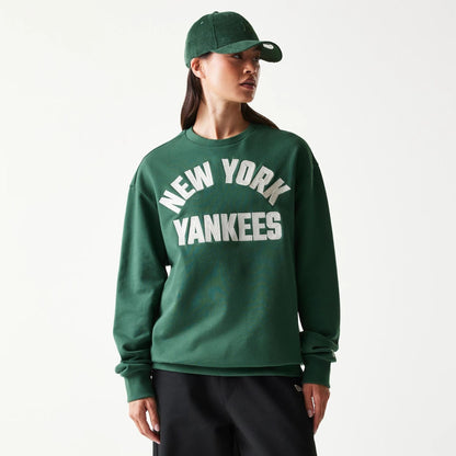 The model is wearing this MLB Graphic New York Yankees Oversized Crew Neck Sweater in dark green. 4