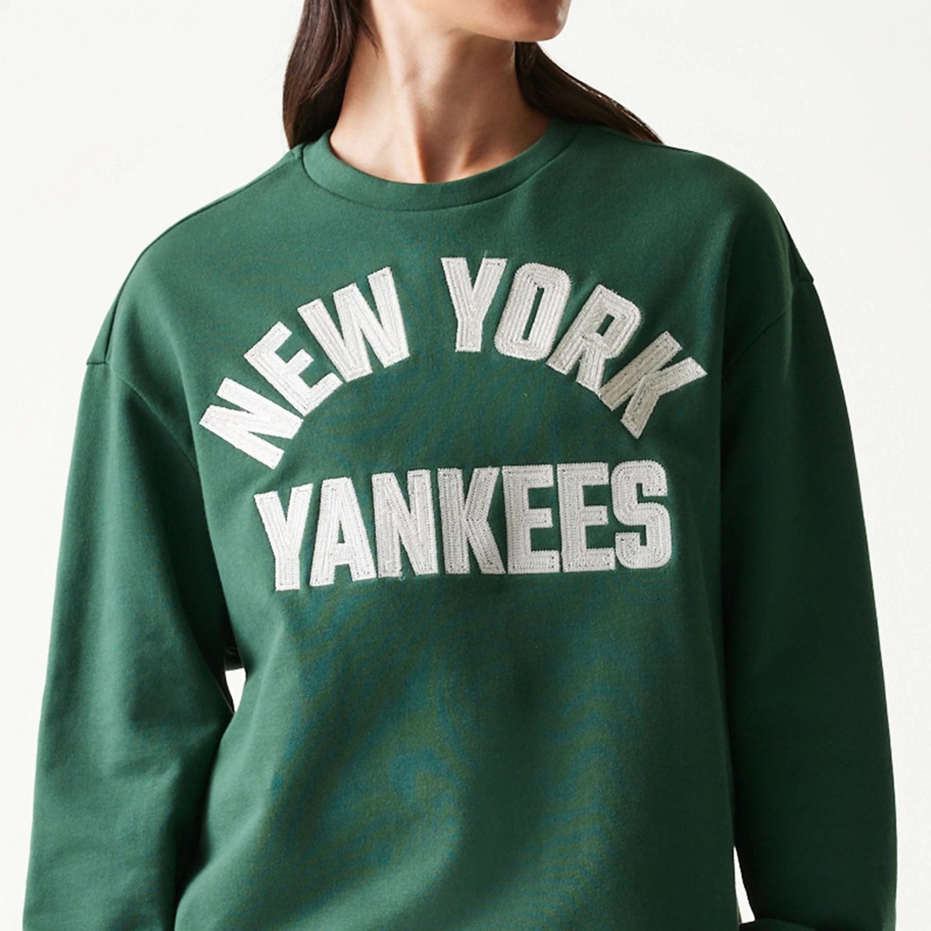 The model is wearing this MLB Graphic New York Yankees Oversized Crew Neck Sweater in dark green. 5