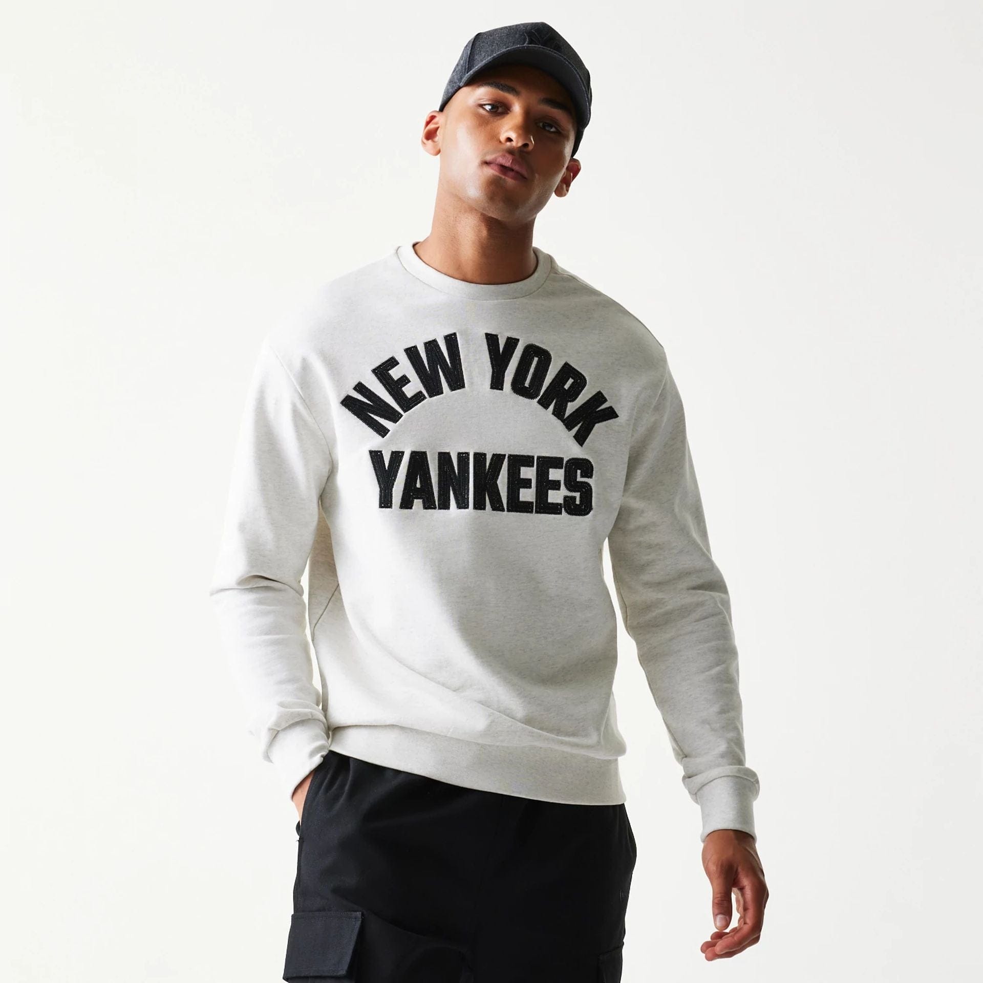 The model is wearing this MLB Graphic New York Yankees Oversized Crew Neck Sweater in pastel grey. 3