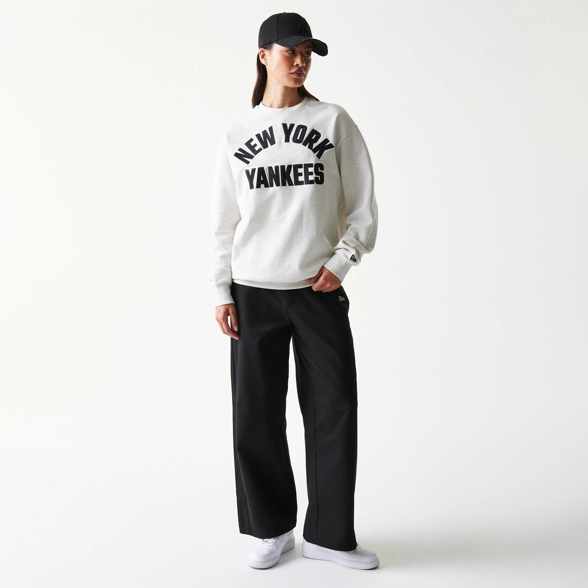 The model is wearing this MLB Graphic New York Yankees Oversized Crew Neck Sweater in pastel grey. 4