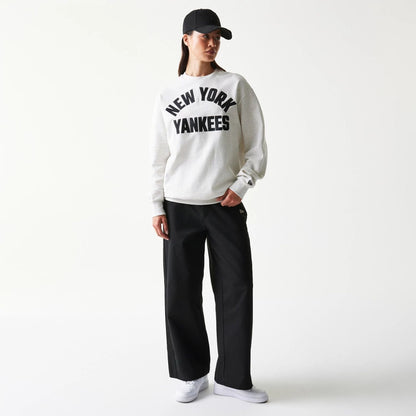 The model is wearing this MLB Graphic New York Yankees Oversized Crew Neck Sweater in pastel grey. 4