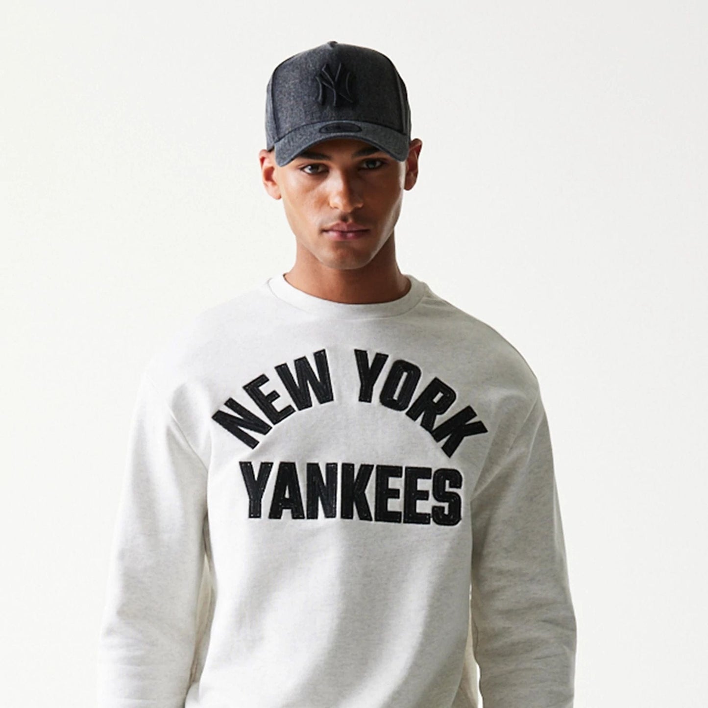 The model is wearing this MLB Graphic New York Yankees Oversized Crew Neck Sweater in pastel grey. 5