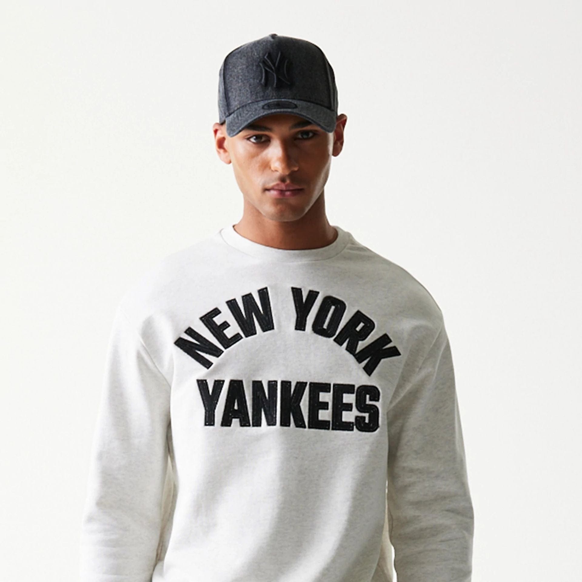 The model is wearing this MLB Graphic New York Yankees Oversized Crew Neck Sweater in pastel grey. 5