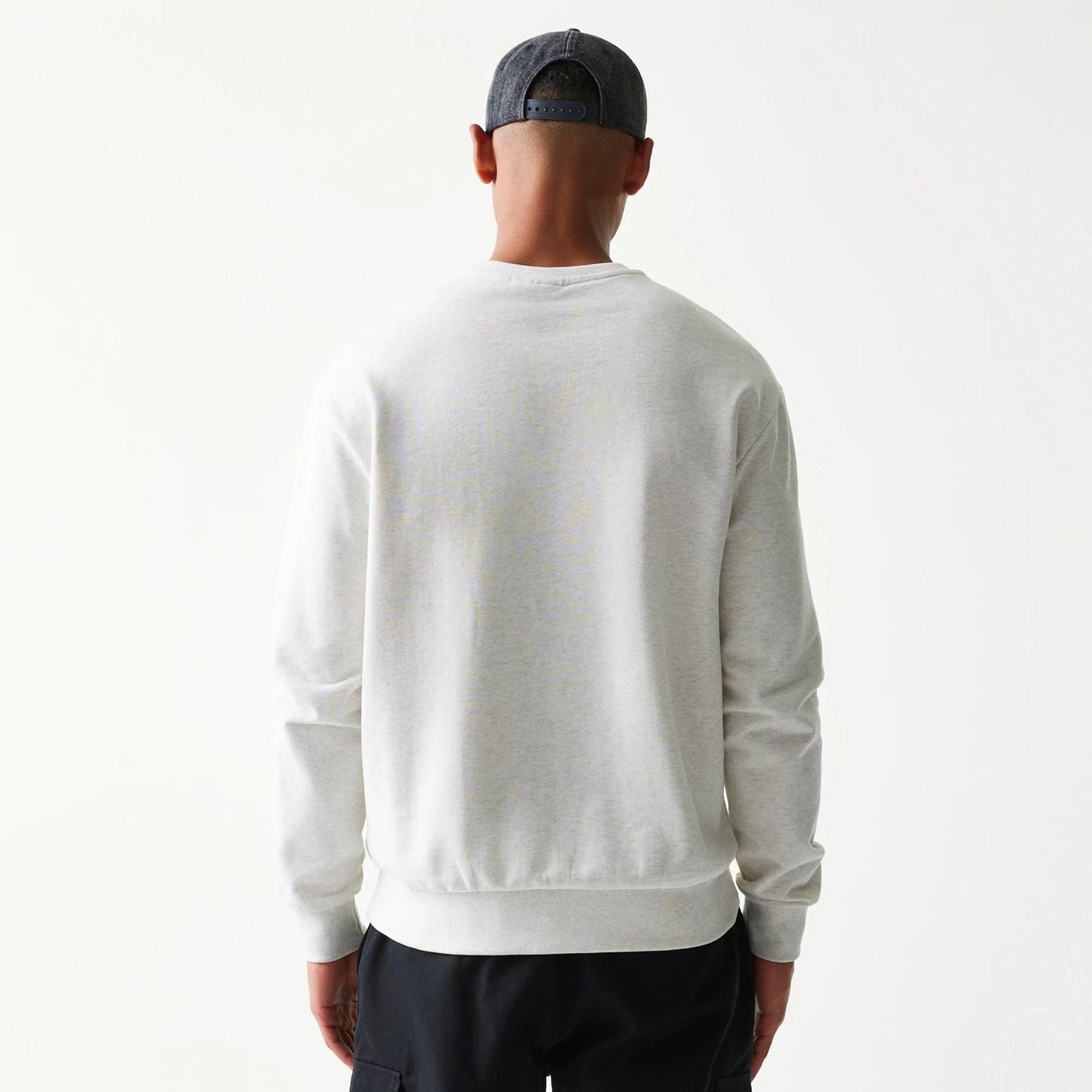 The model is wearing this MLB Graphic New York Yankees Oversized Crew Neck Sweater in pastel grey. 2
