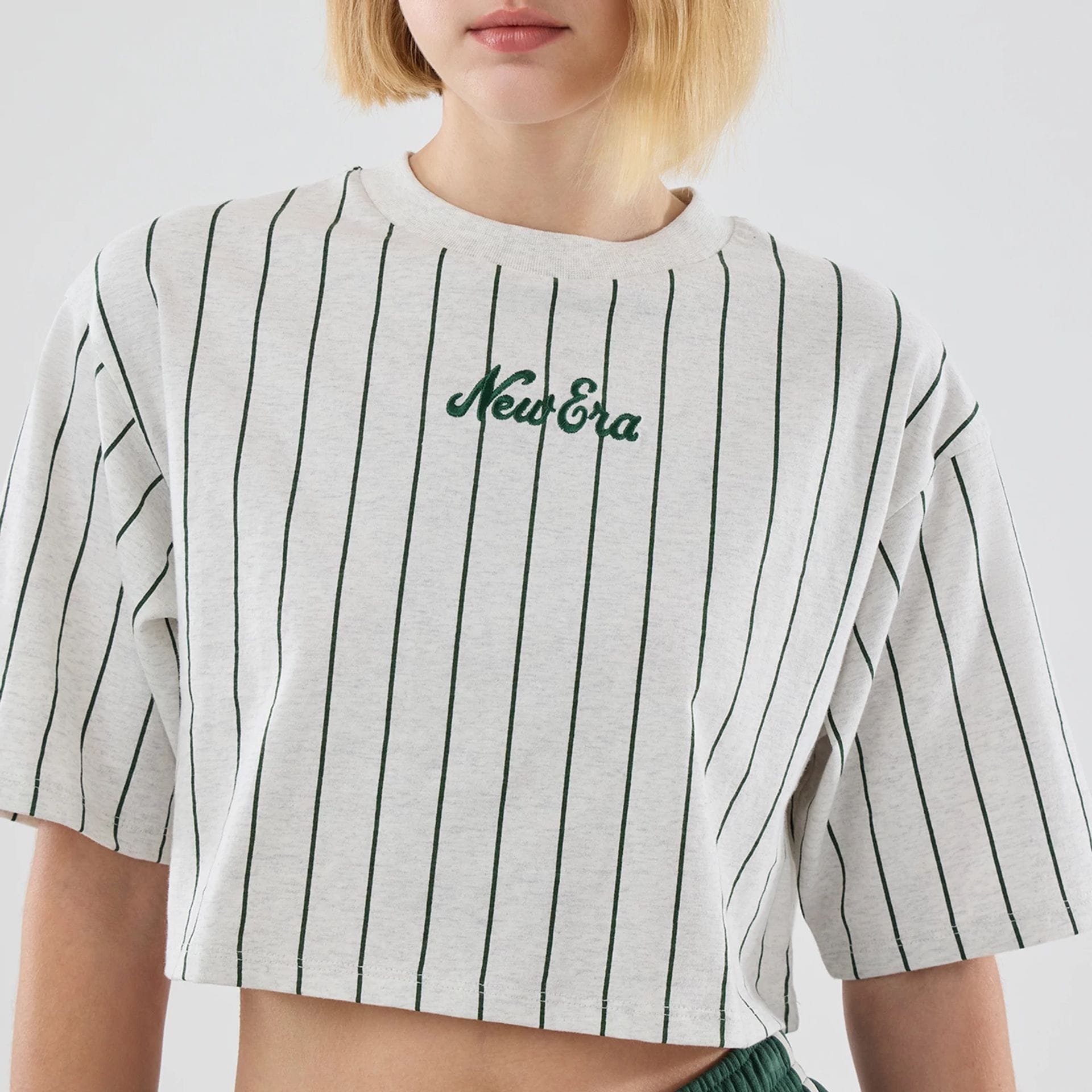 The model is wearing this Womens New Era Pinstripe Cropped T-shirt in pastel grey. 4