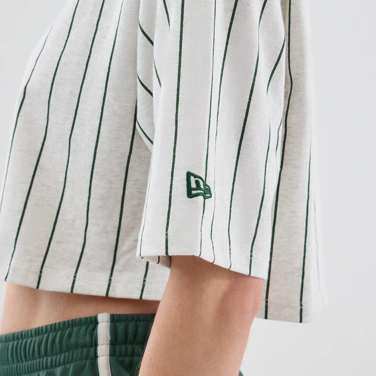 The model is wearing this Womens New Era Pinstripe Cropped T-shirt in pastel grey. 5