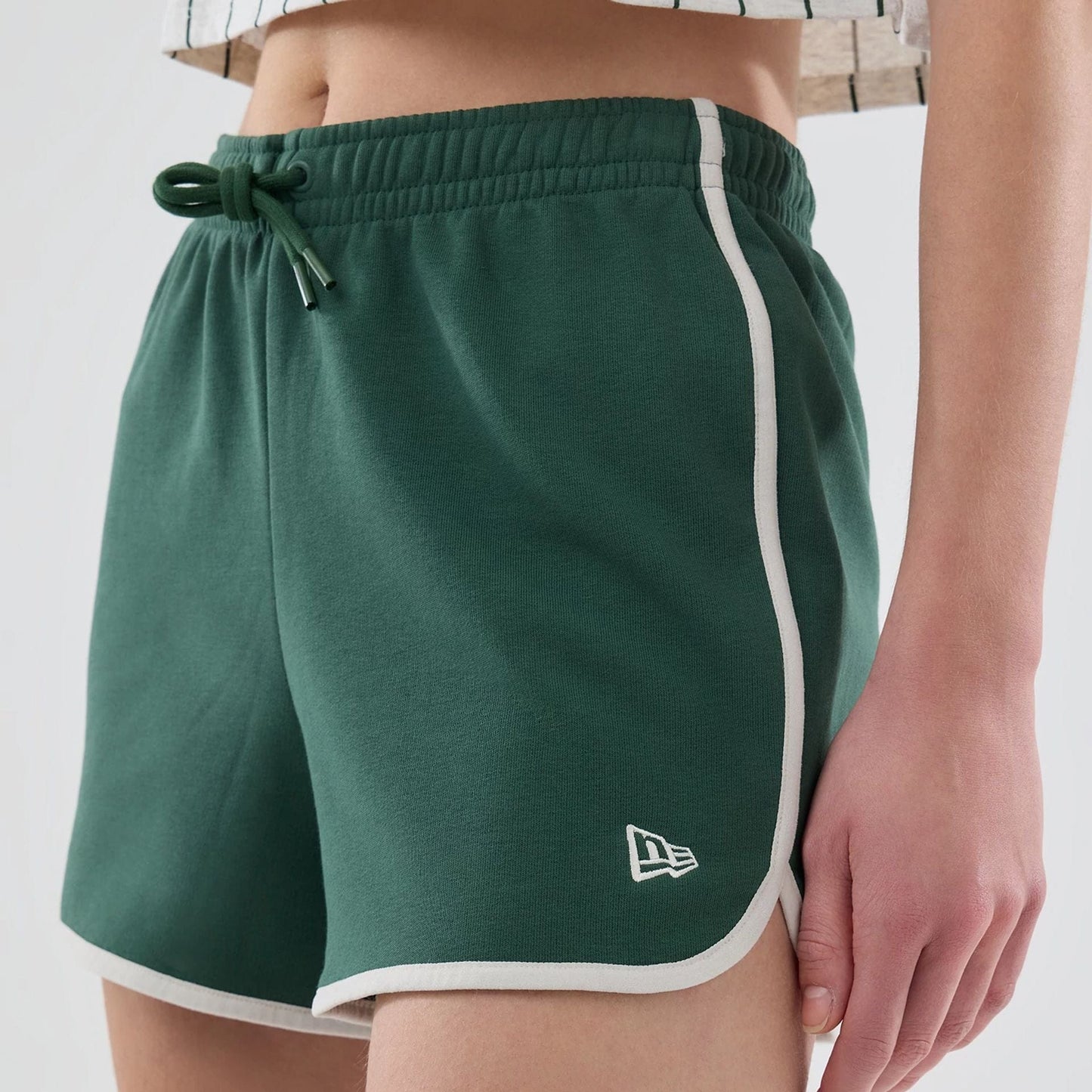 The model is wearing this Womens New Era Track Shorts in dark green. 5