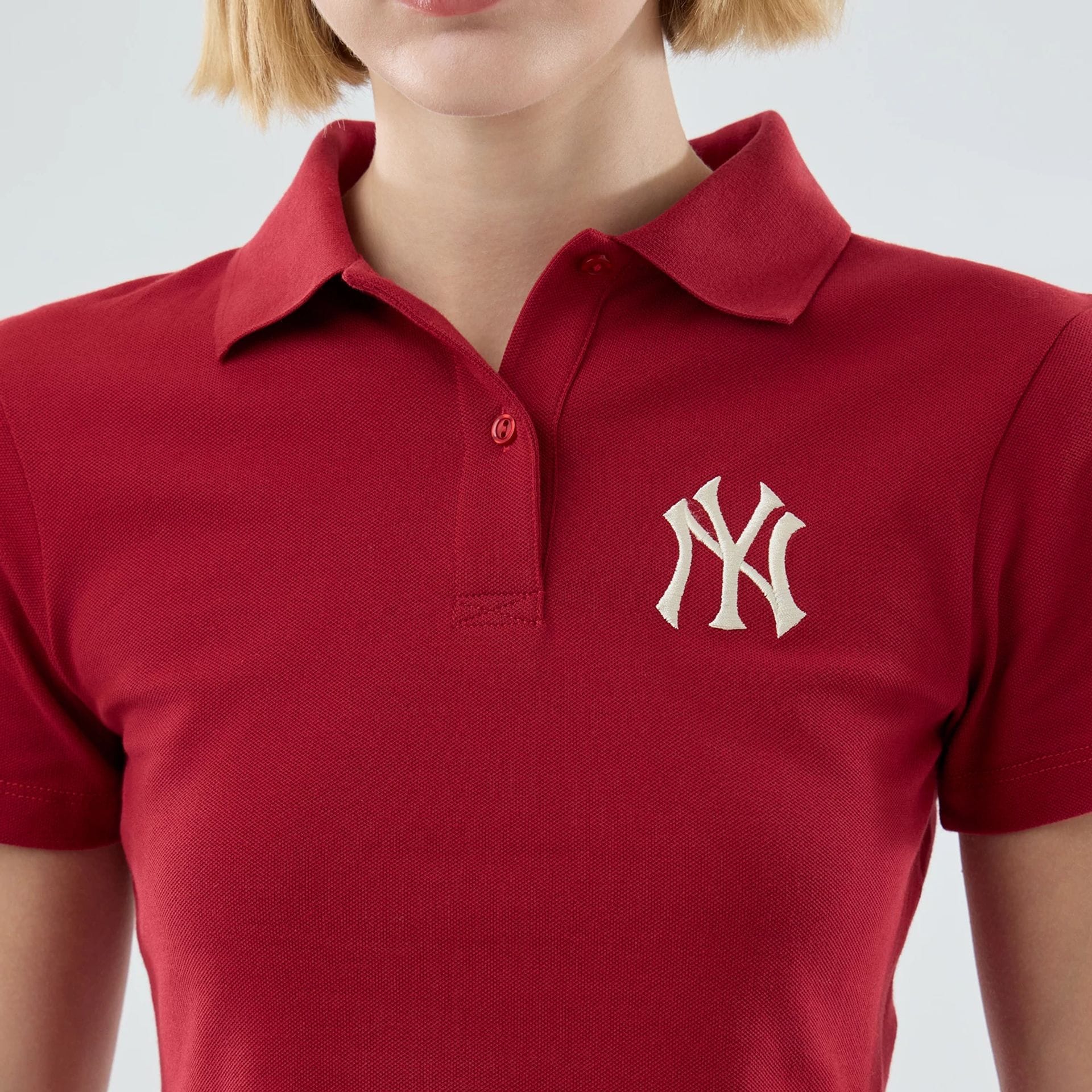 The model is wearing this Womens MLB New York Yankees Cropped Slim Polo T-shirt in dark red. 4