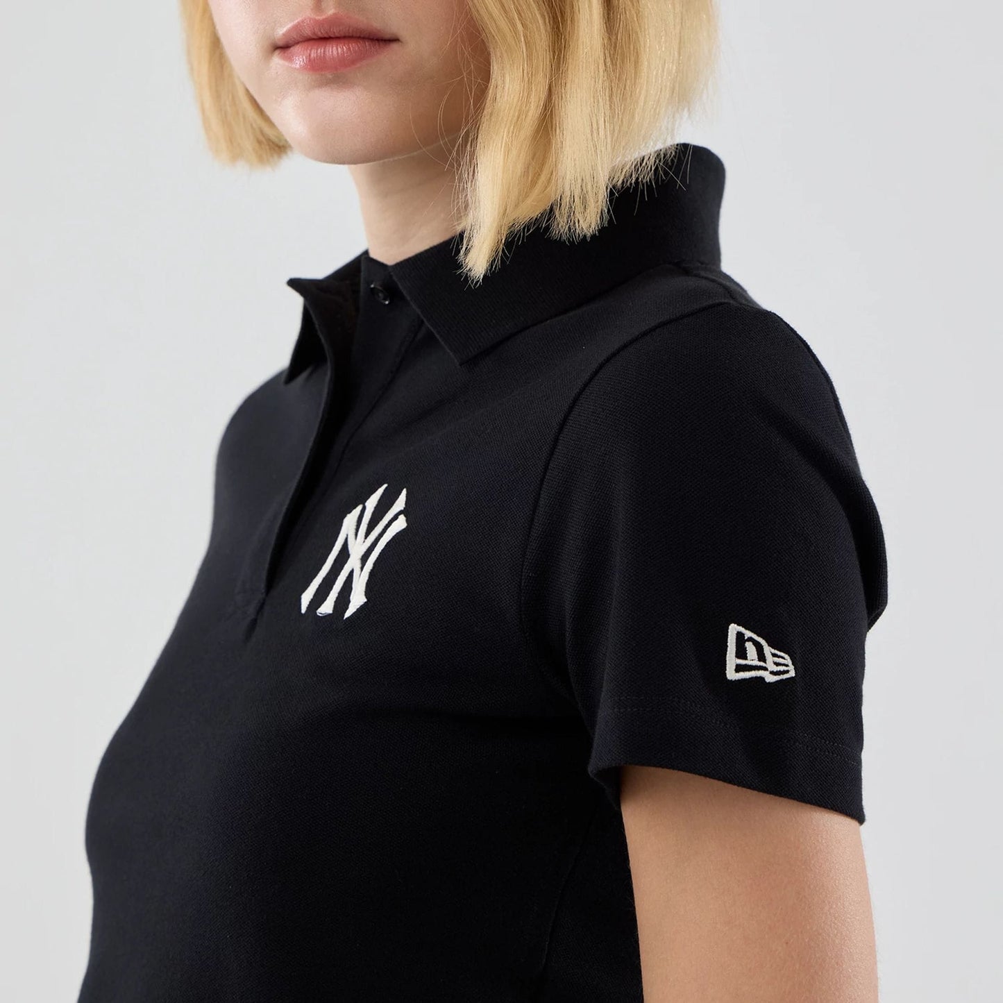 The model is wearing this Womens MLB New York Yankees Cropped Slim Polo T-shirt in black. 5