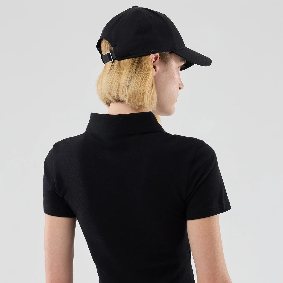 The model is wearing this Womens MLB New York Yankees Cropped Slim Polo T-shirt in black. 7