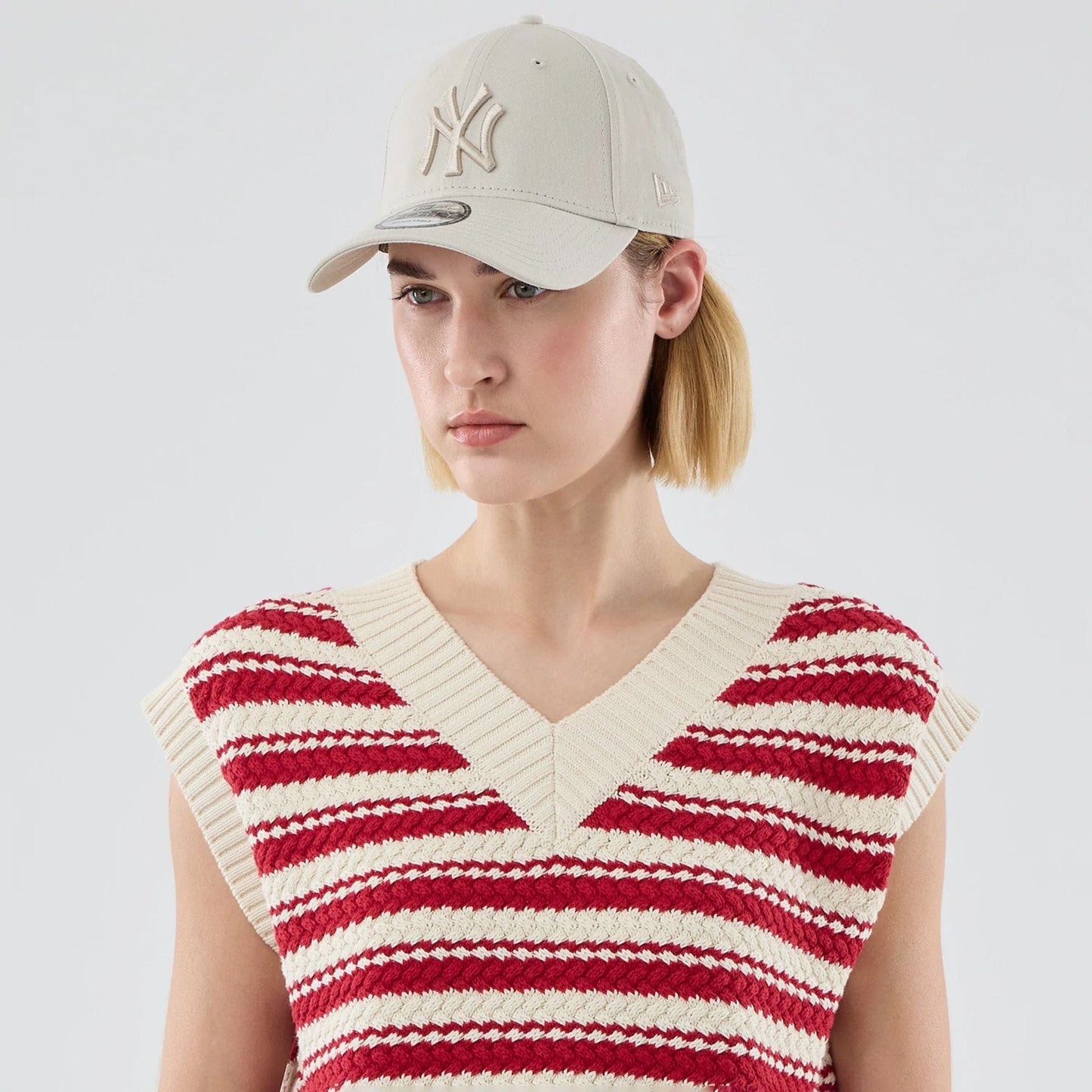 The model is wearing this Womens MLB Knit Stripe New York Yankees Sleeveless  V-neck Sweater in dark red. 6