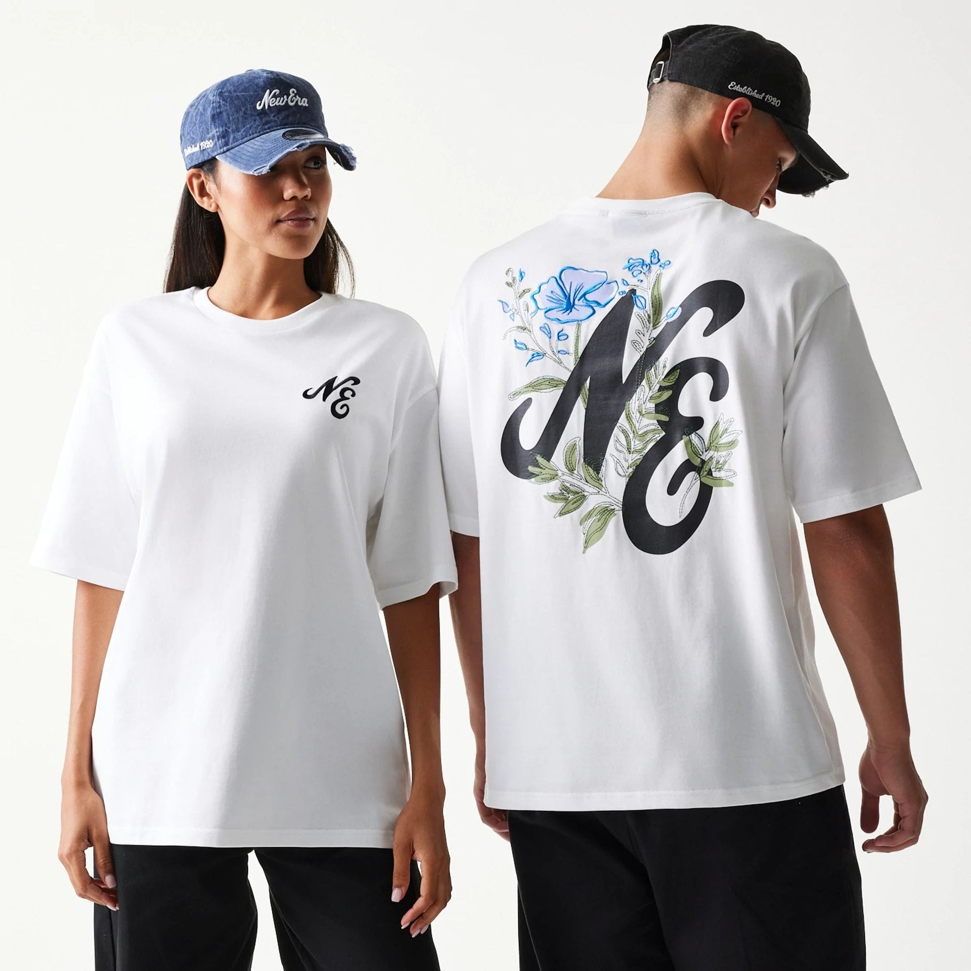 The model is wearing this New Era Floral Graphic Oversized T-Shirt in white. 1