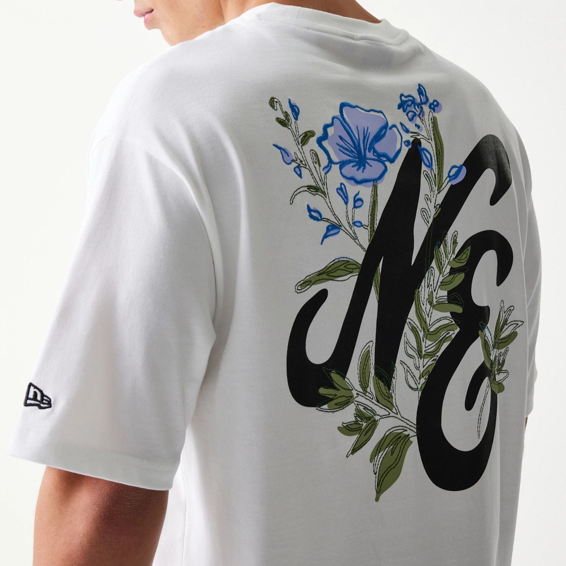 The model is wearing this New Era Floral Graphic Oversized T-Shirt in white. 7